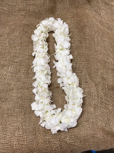 White flower lei on burlap fabric