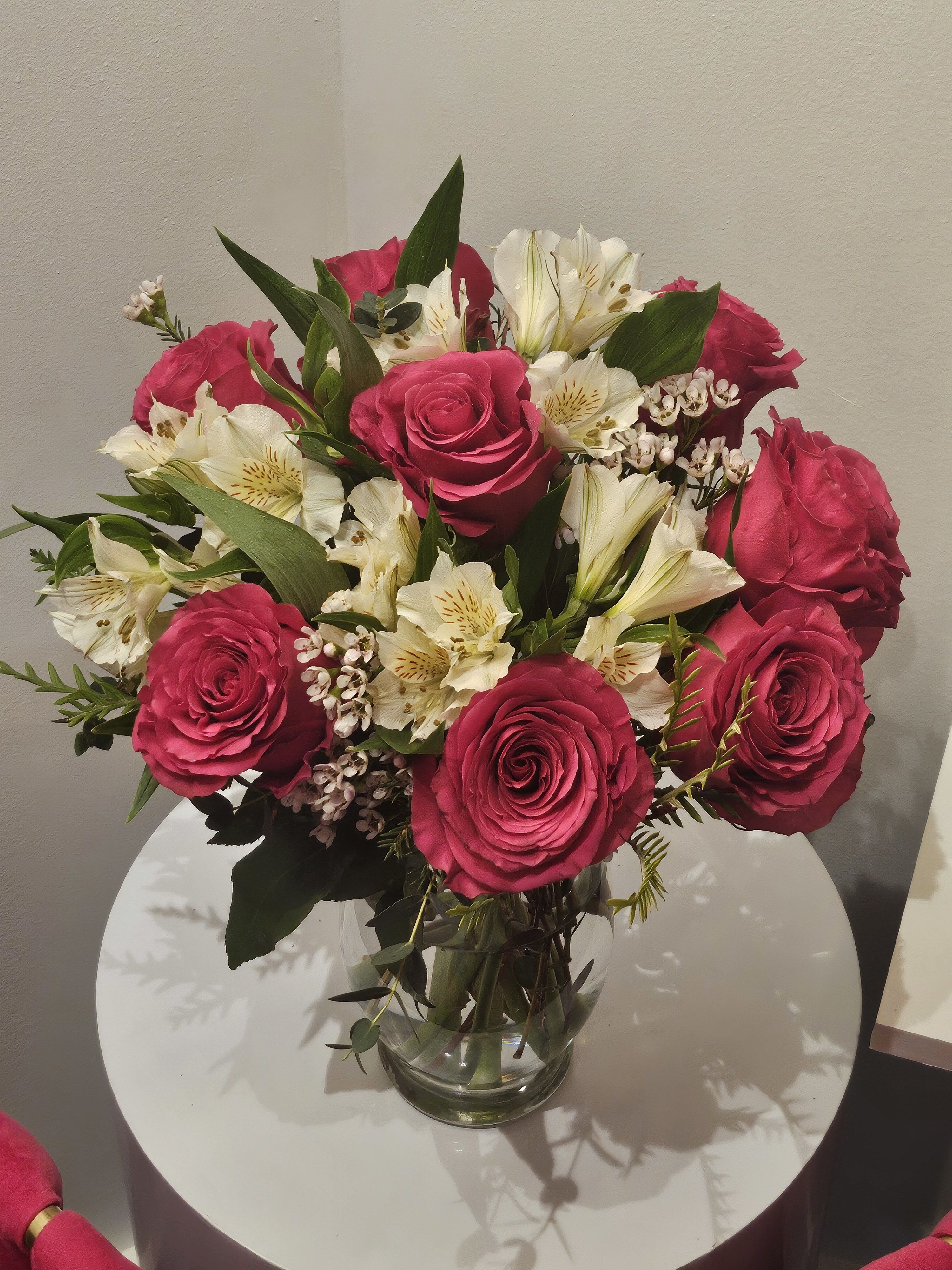 Pink roses and white lilies arranged in a clear glass vase