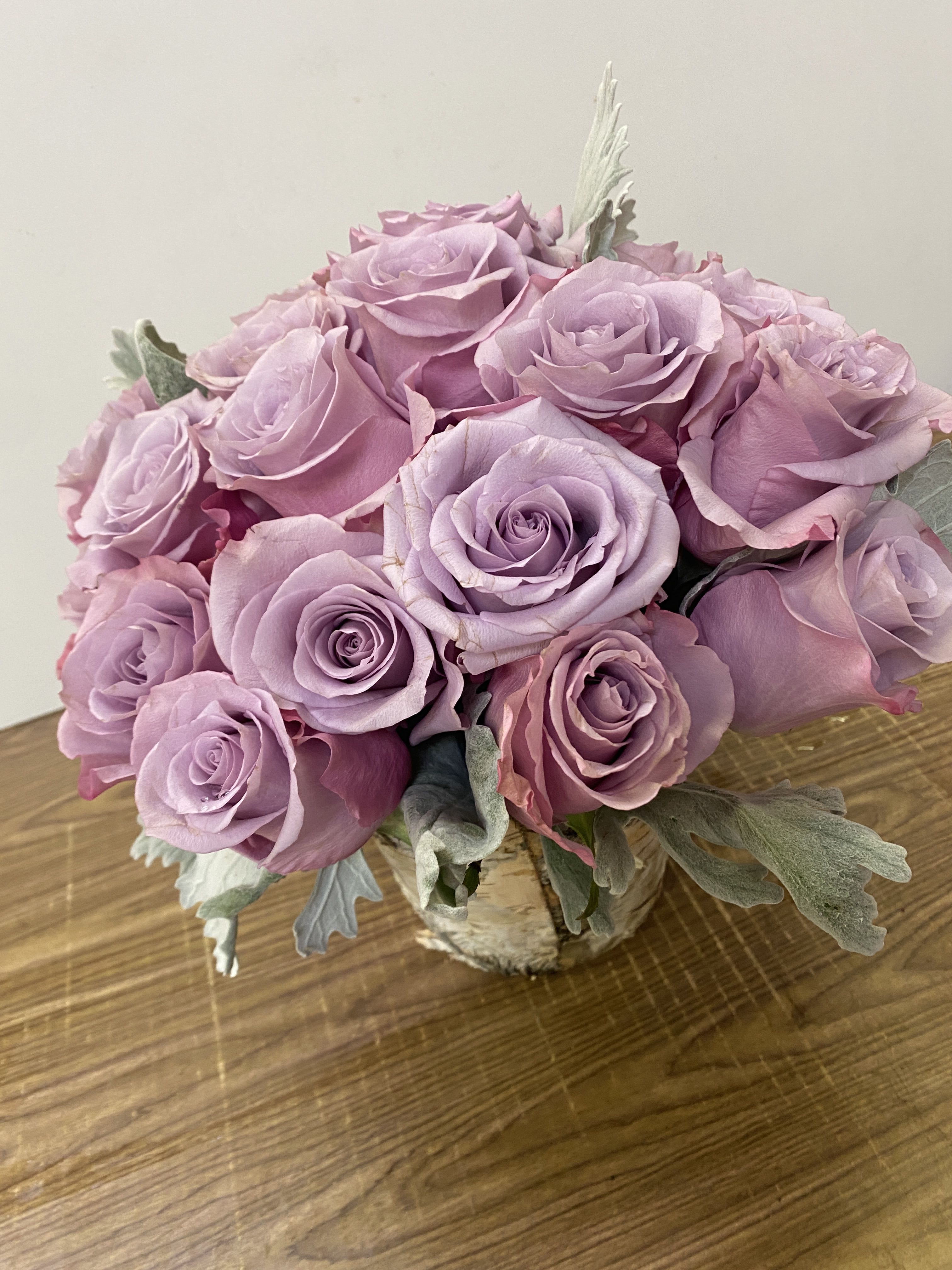 Bouquet of lavender roses in a small wrapped container