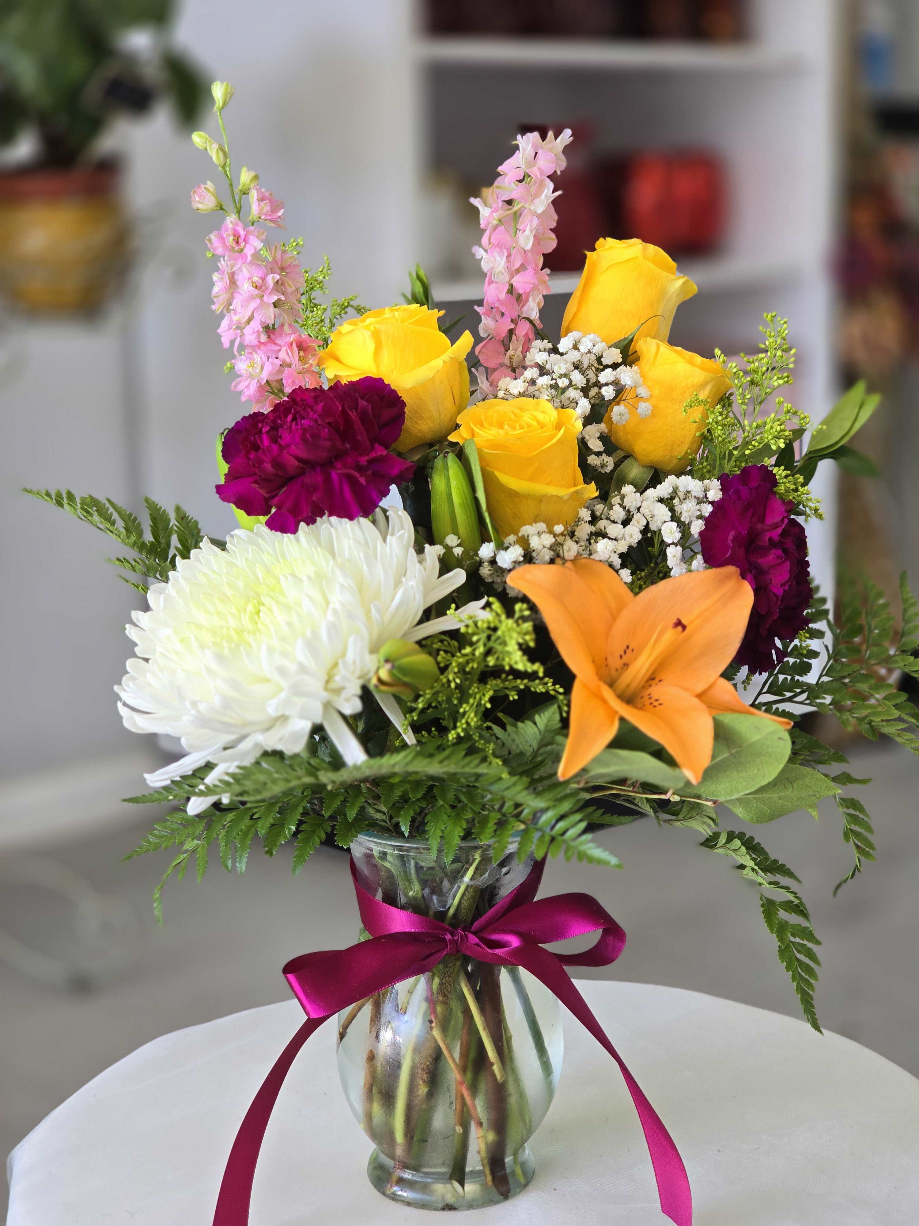 Sunny Mix 4055 - Yellow roses with orange lilies in a glass vase.