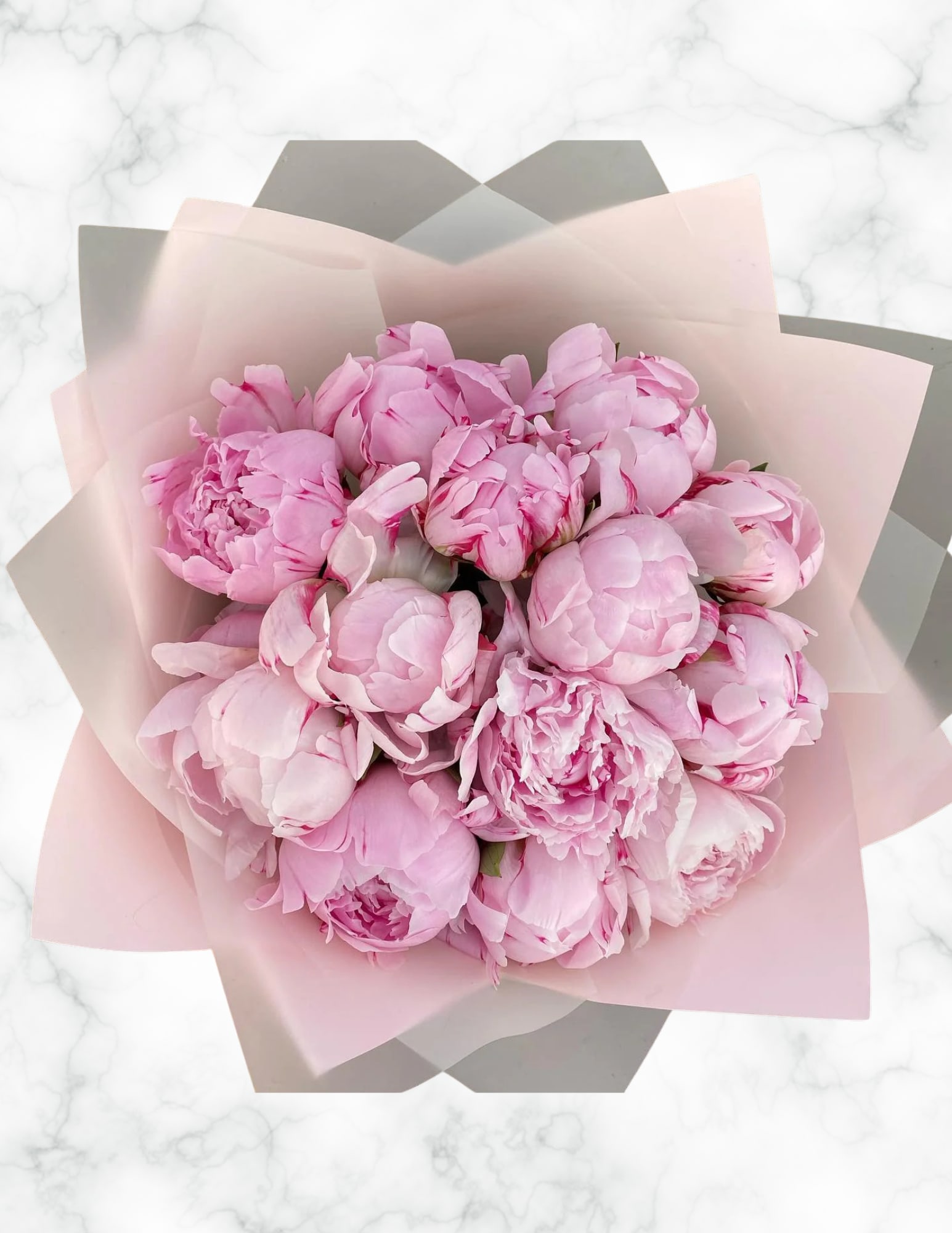 Bouquet of pink peonies wrapped in pale pink paper