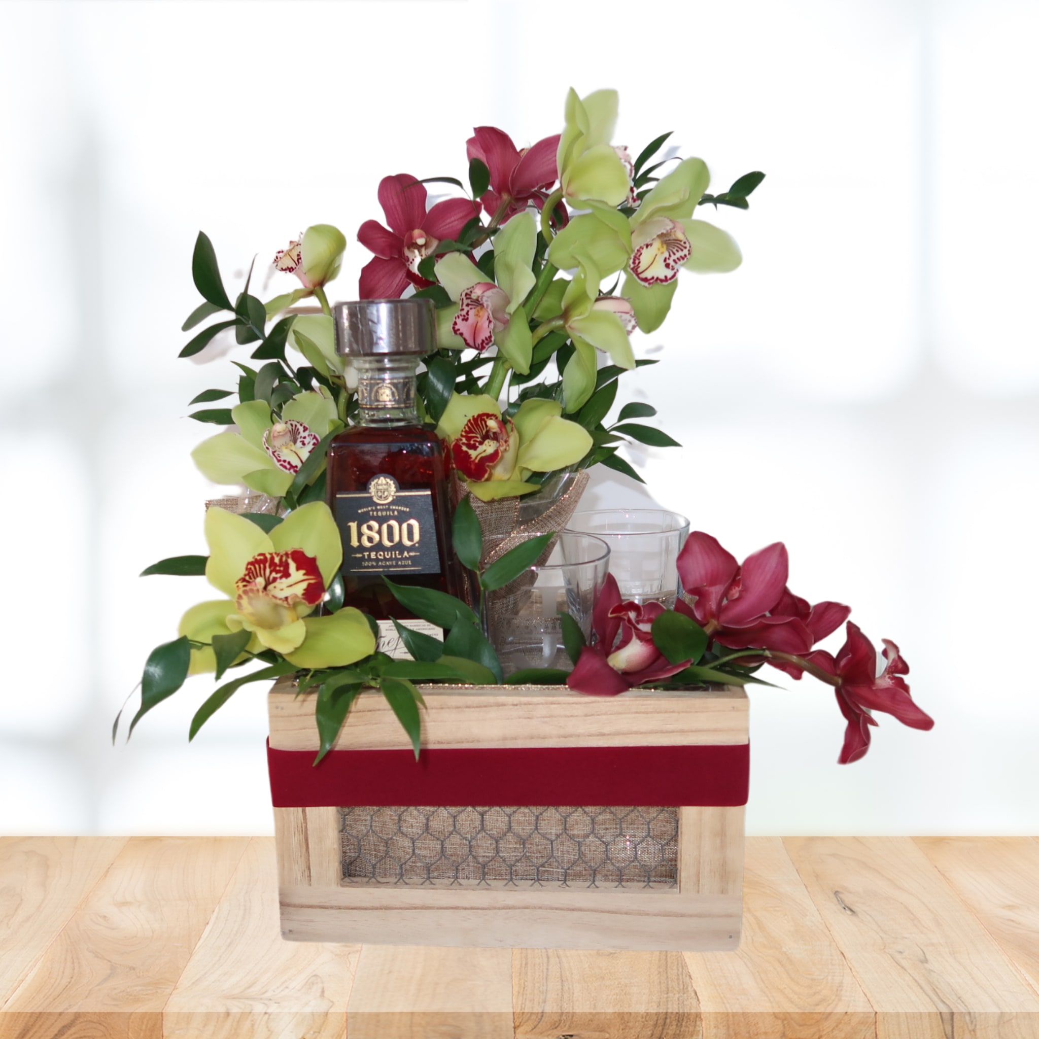 Arreglo personalizado para caballeros en Long Island New York - Este es un arreglo personalizado para ellos. Incluye: -Cymbidium orchids de dos colores. -1 botella de tequila 1800 añejo. -4 Vasos de whisky con Inicial y apellido (por ser vasos personalizados necesitas realizar la orden 2 semanas antes de la fecha en que quieres enviarlo)  Si quieres el mismo diseño con flores y bebida más asequibles y sin personalizar los vasos, contactame directo a mi numero 631-809-6363. 