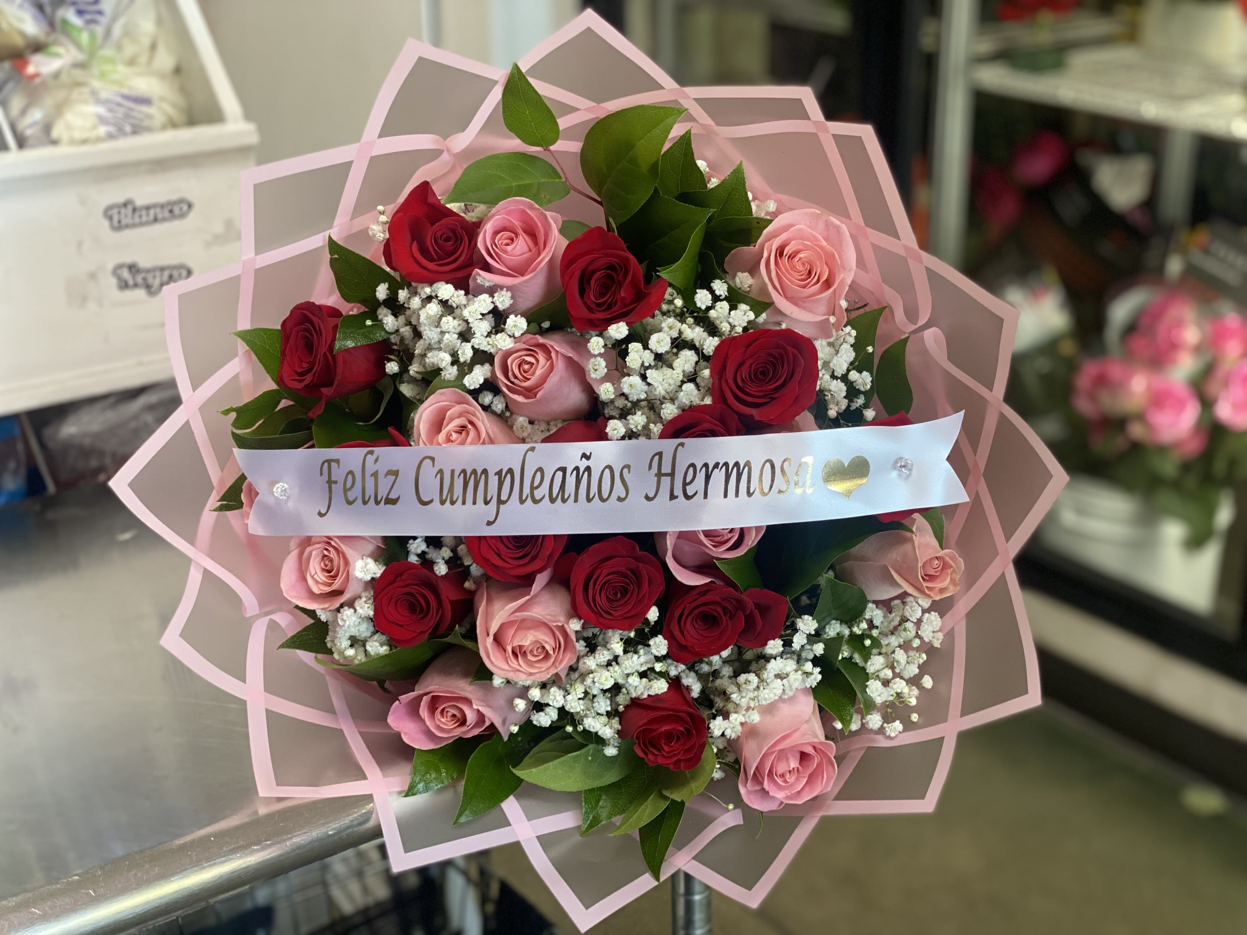 Bouquet of red and pink roses with baby's breath and a birthday ribbon