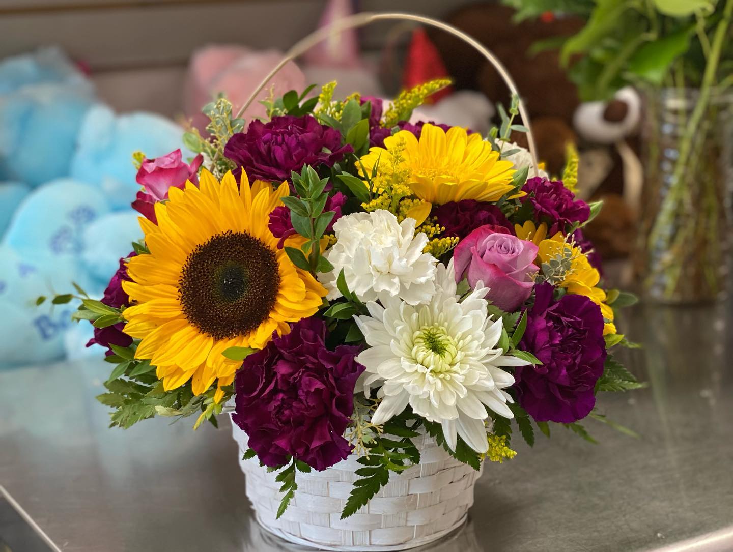 Basket arrangement with sunflowers, roses, chrysanthemums, and carnations