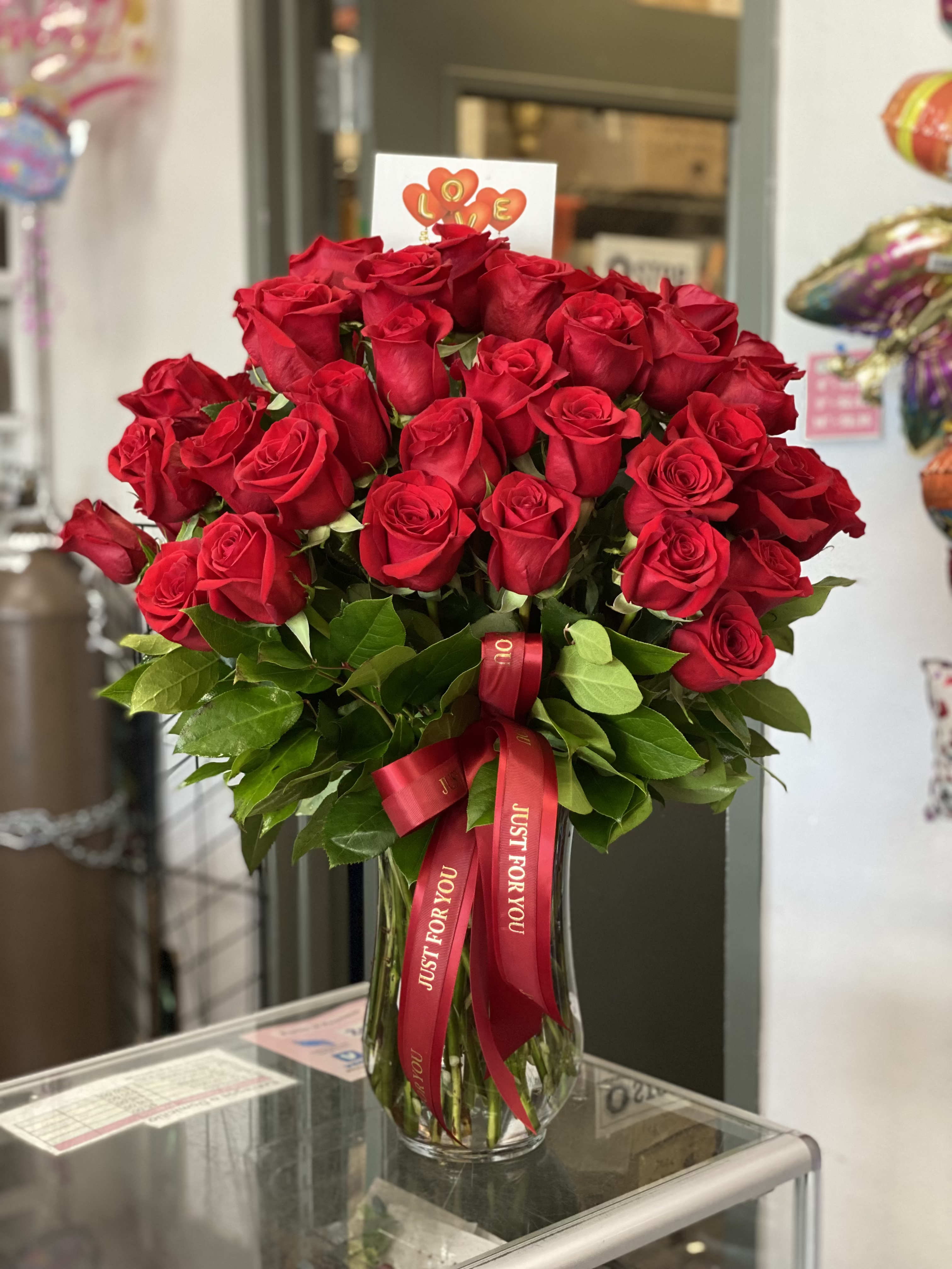 Bouquet of red roses in a glass vase with a red ribbon