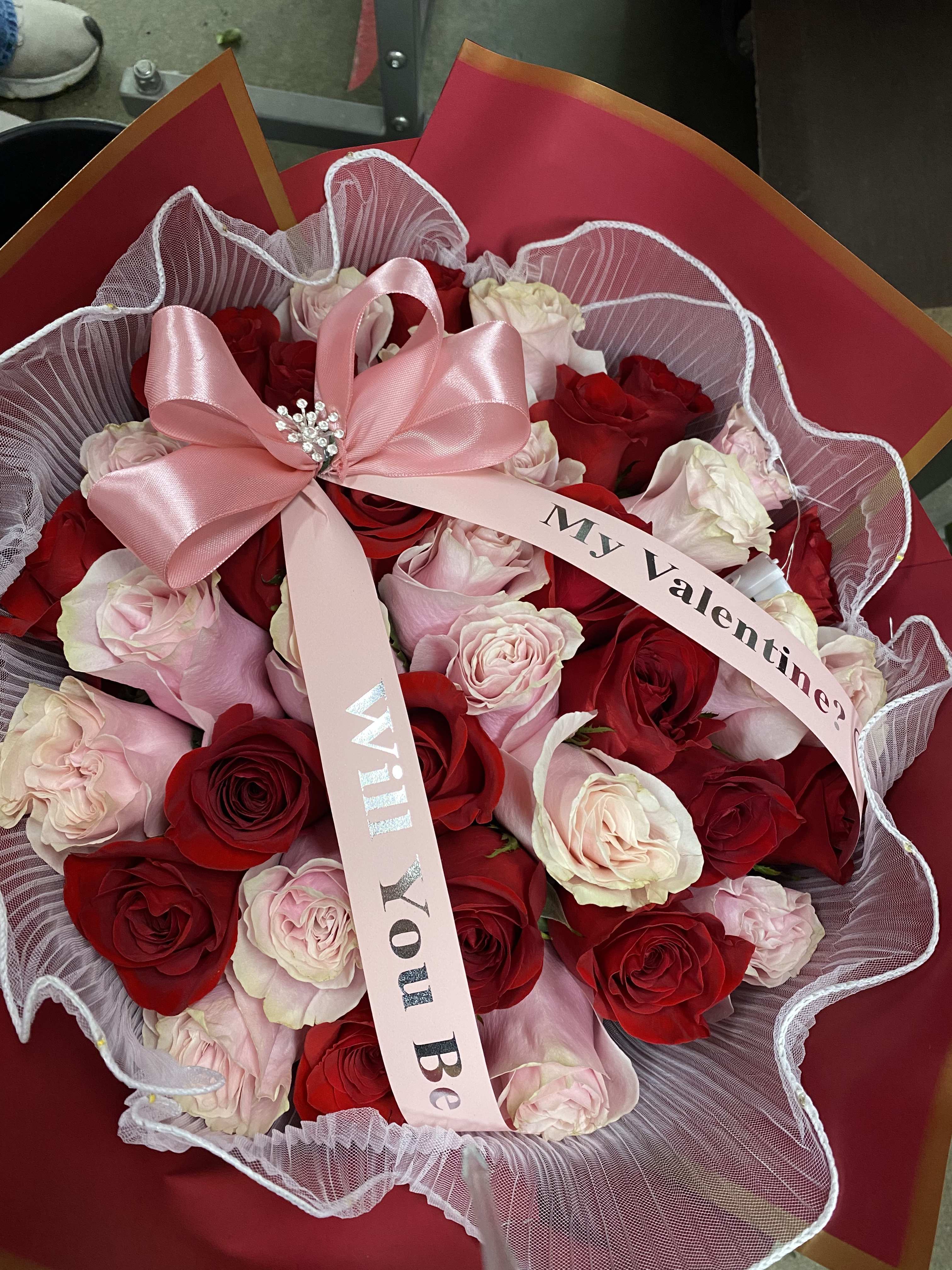 Bouquet of red and pale pink roses with a pink ribbon