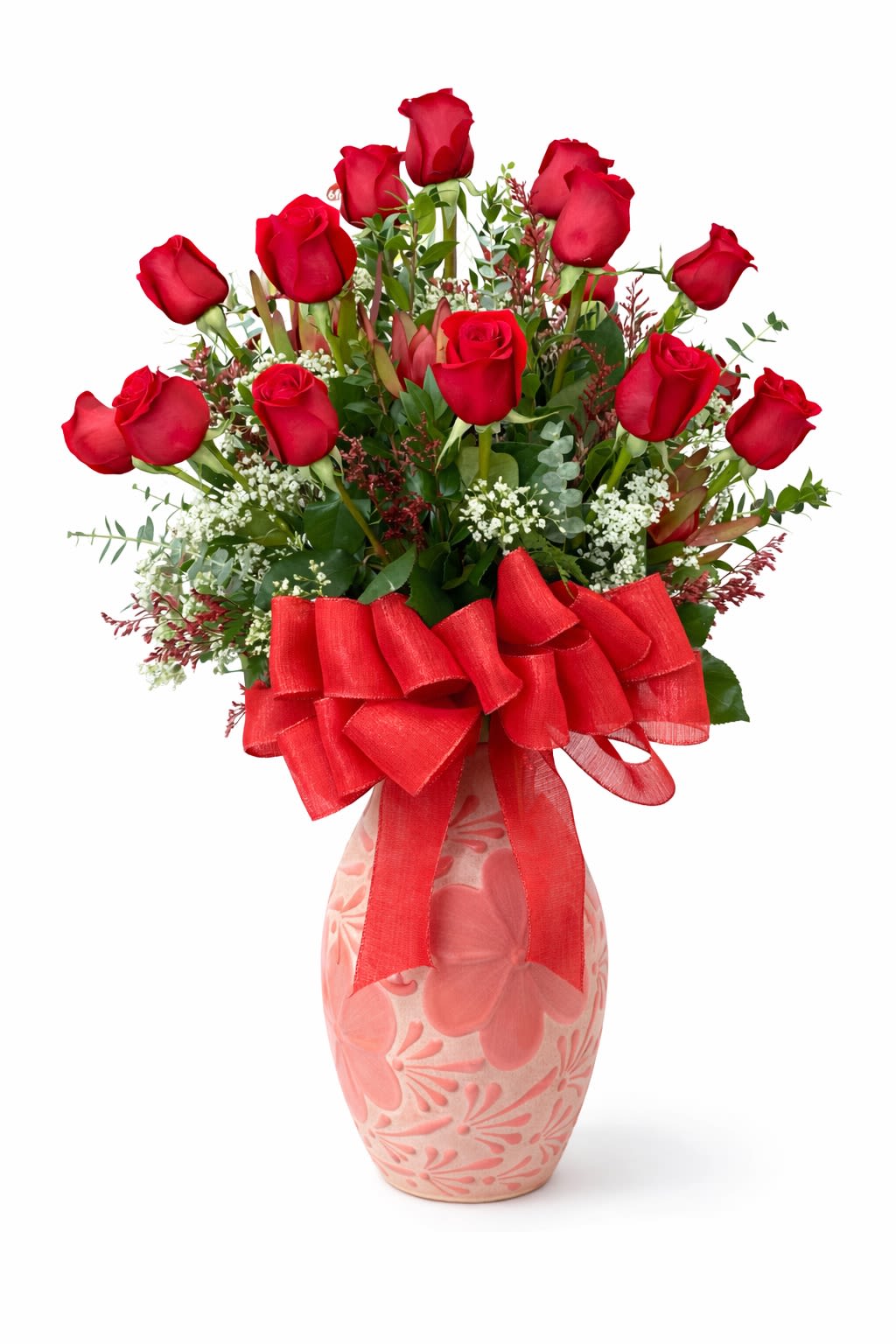 Red roses arranged in a pink patterned vase with a large red bow