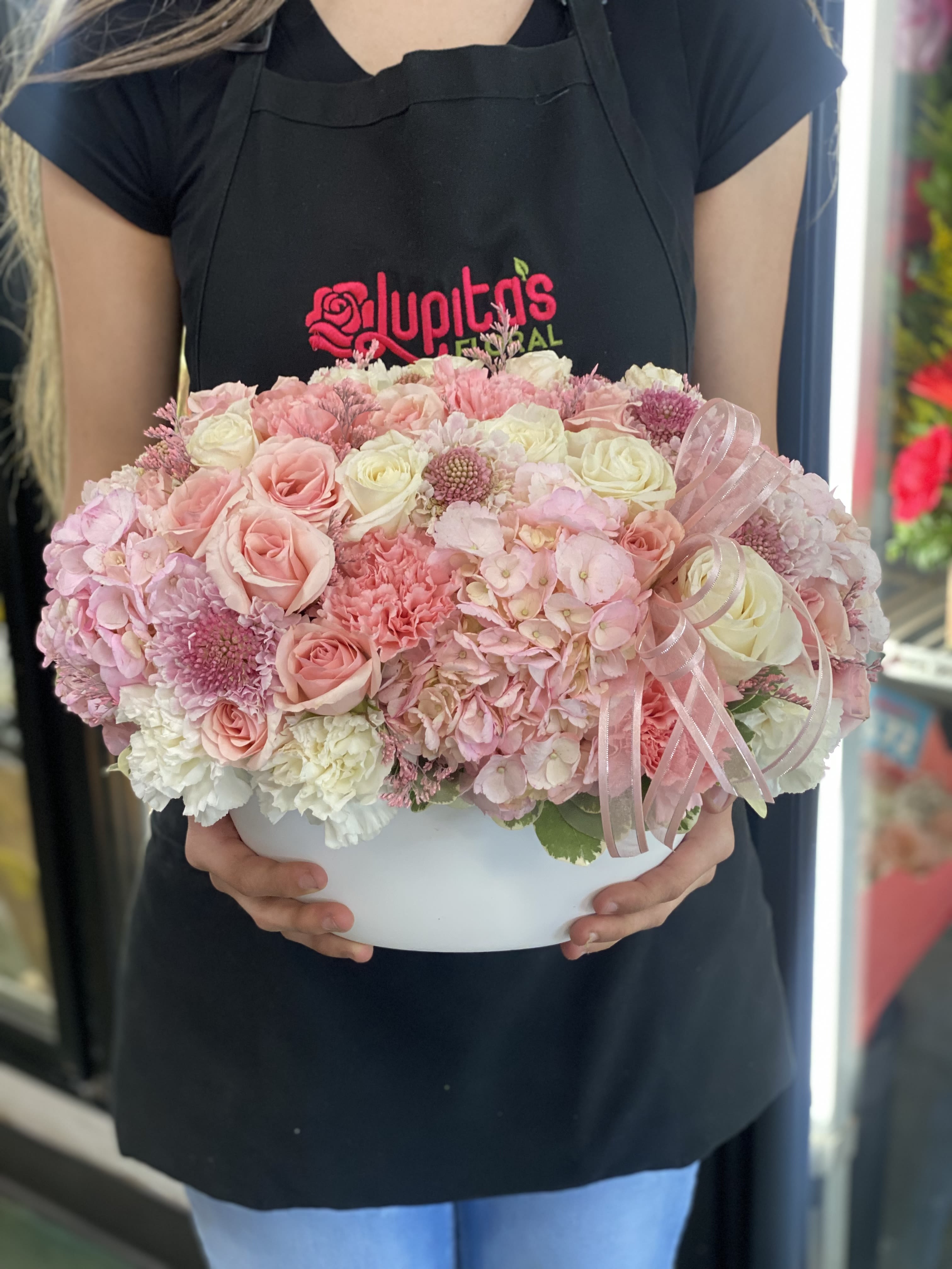 Pink and white rose arrangement in a white hat box with ribbon