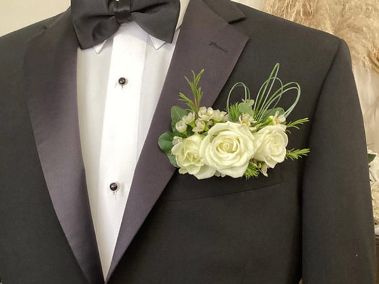 White rose boutonniere on a black tuxedo lapel