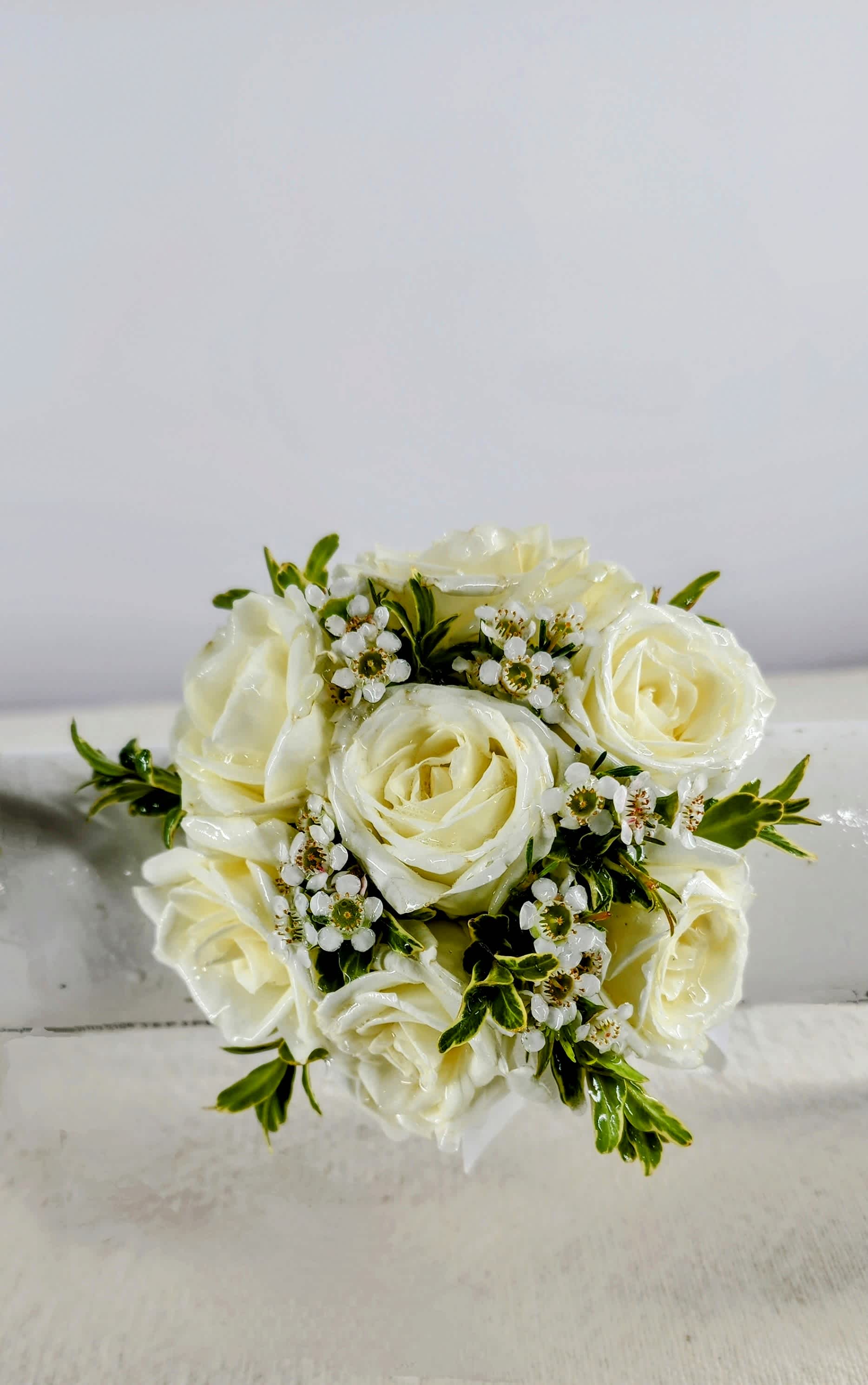 Cream rose bouquet with small white filler flowers and green accents