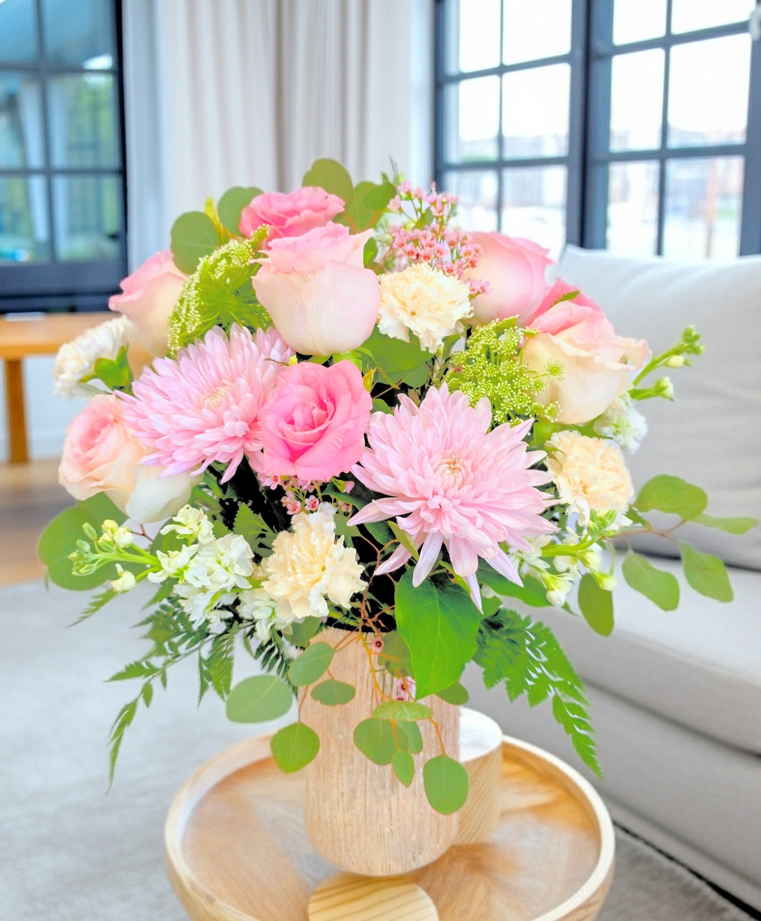Fit For A Queen  - Soft pastels of pink, white and green come together in a rounded flower arrangement that reads like a warm, floral hug - perfect as a Mother's Day bouquet, a spring celebration gift, or a thoughtful way to say thank you. The compact, romantic design uses roses, large pink chrysanthemums and carnations with delicate blush and white filler blooms so the person you're thinking of will feel genuinely cherished the moment they see it.