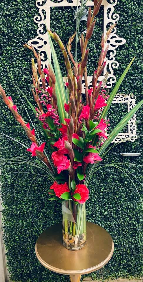 Tall pink floral arrangement in a clear glass vase