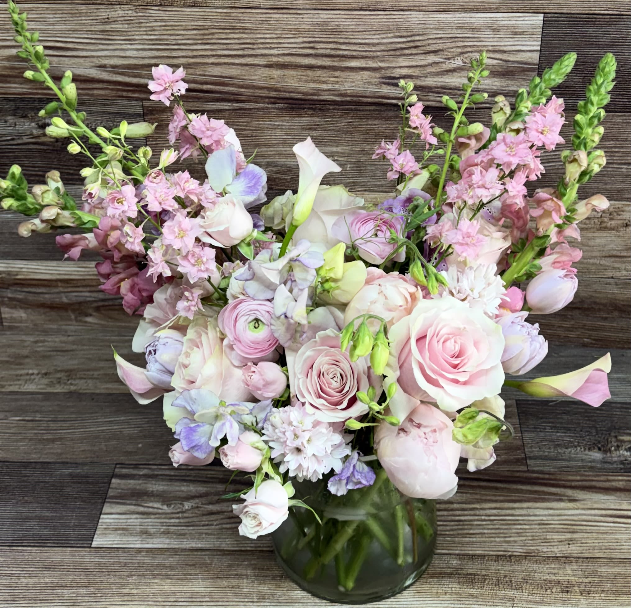 Soft pinks with a touch of purple luxury bouquet - Large bouquet of premium blooms including roses, peonies, ranunculus, hyacinths and other seasonal soft pinks and purples in a heavy duty pyramid cylinder vase. Not available same day as I may need time to source flowers.