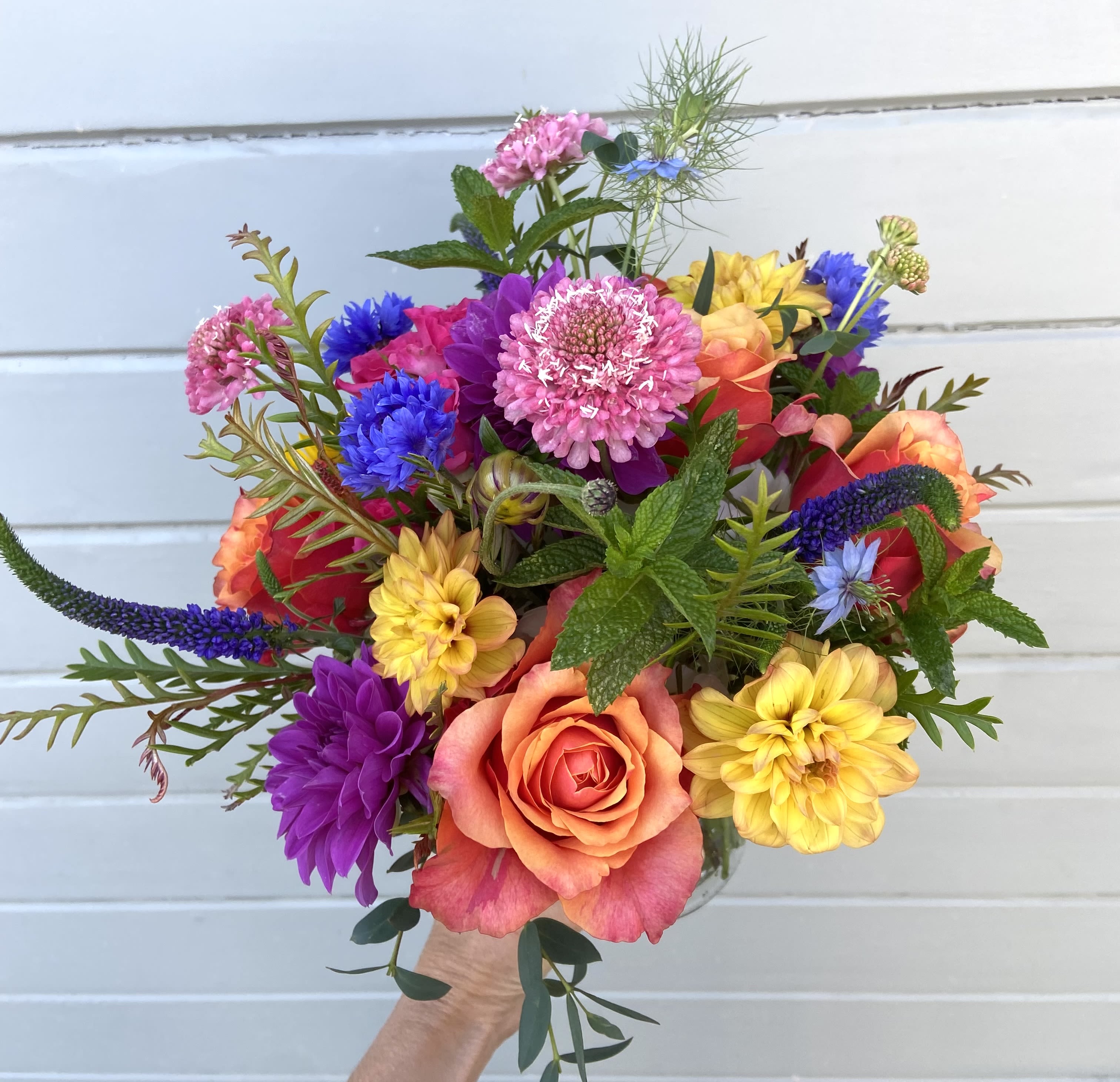 Colorful bouquet with roses, dahlias, and blue accent flowers