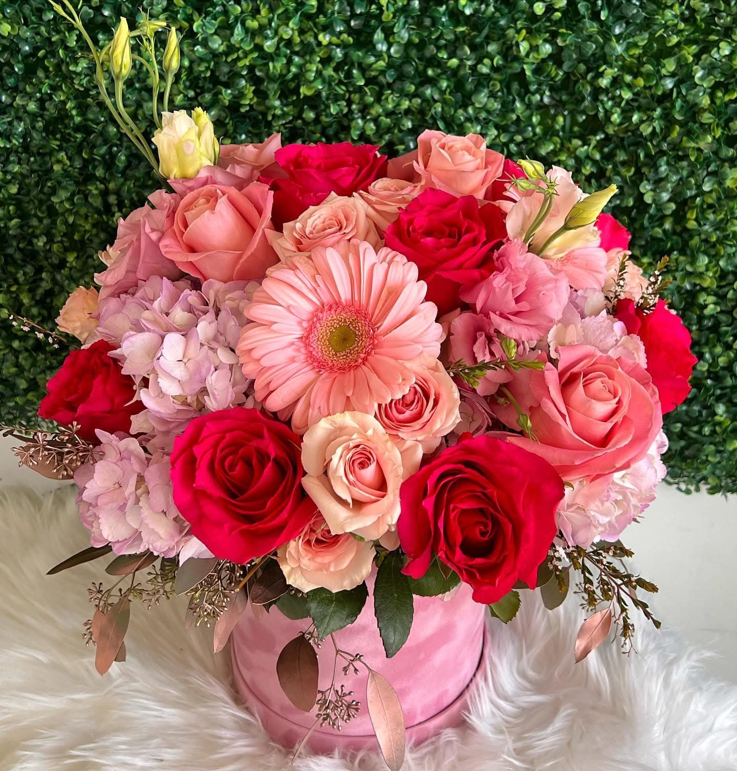 Pink and red rose bouquet with a gerbera daisy in a pink hatbox