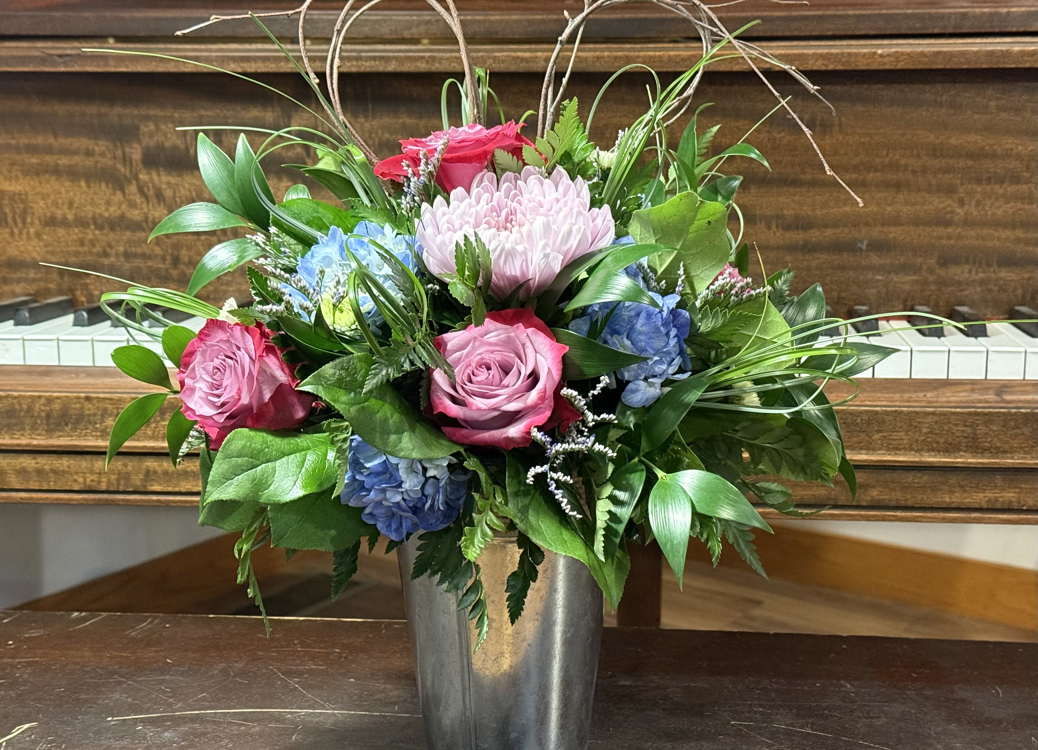 Spring Delight - This is the perfect Summer Arrangement for any table or host. Beautiful summer blooms and fun twigs for accent.  