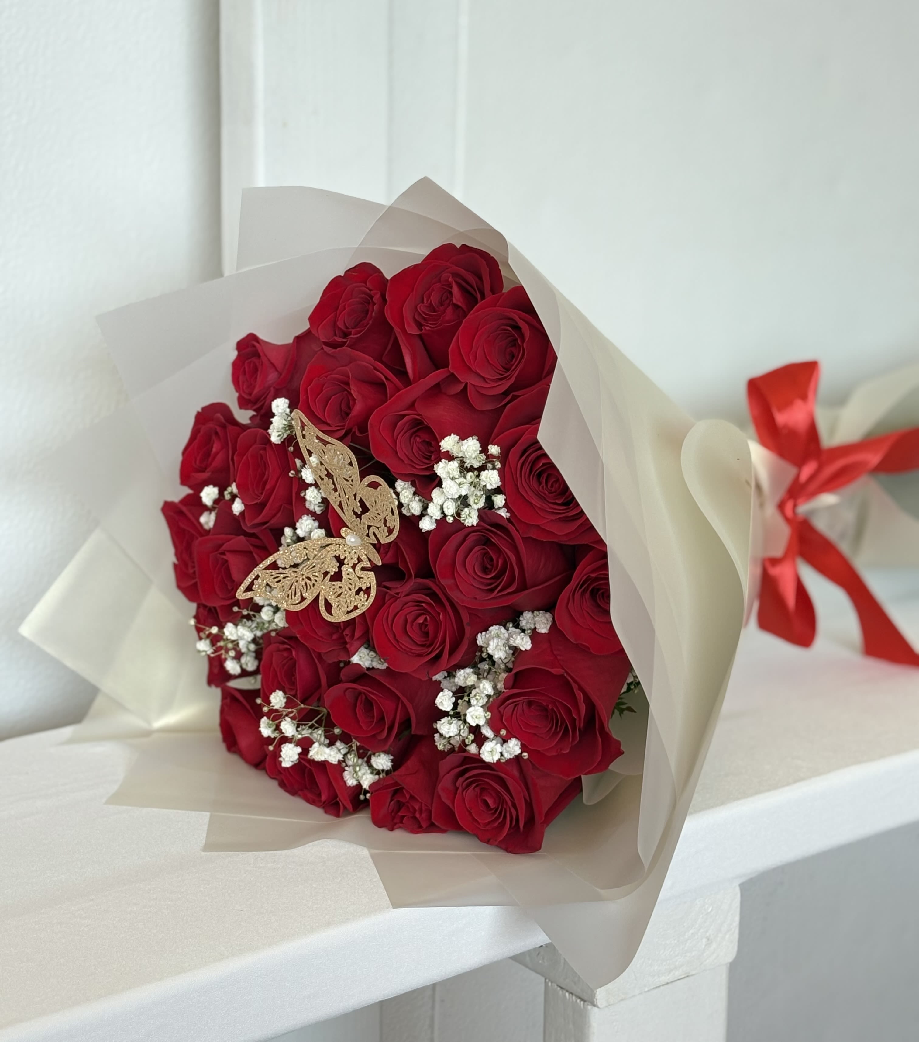 Bouquet of red roses with baby's breath in cream wrapping