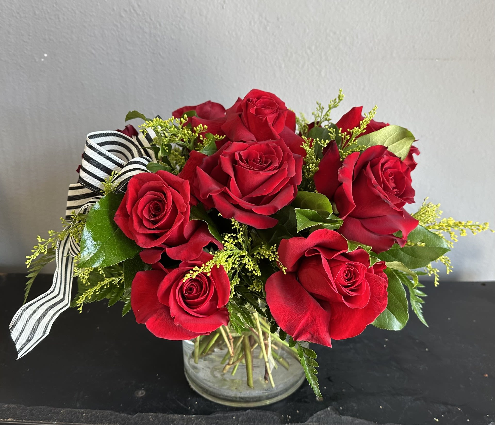 1 Dozen Red Roses--Short &amp; Compact - Beautifully designed in a 5x5 clear vase using imported long stem red roses with greens and filler. Greens and filler WILL vary. Life expectancy 3-5 Day depending on room temp and care of the flowers.