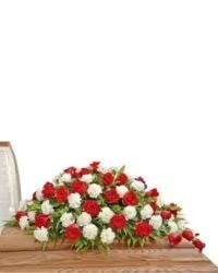 Classic Red &amp; White Casket Spray - A timeless and elegant casket spray featuring a harmonious blend of red and white carnations, accented with lush fresh greens and highlighted with beautiful roses. This classic design offers a dignified and heartfelt tribute, perfect for honoring a loved one with grace and tradition.
