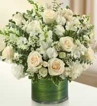 White roses and hydrangeas arranged in a green vase