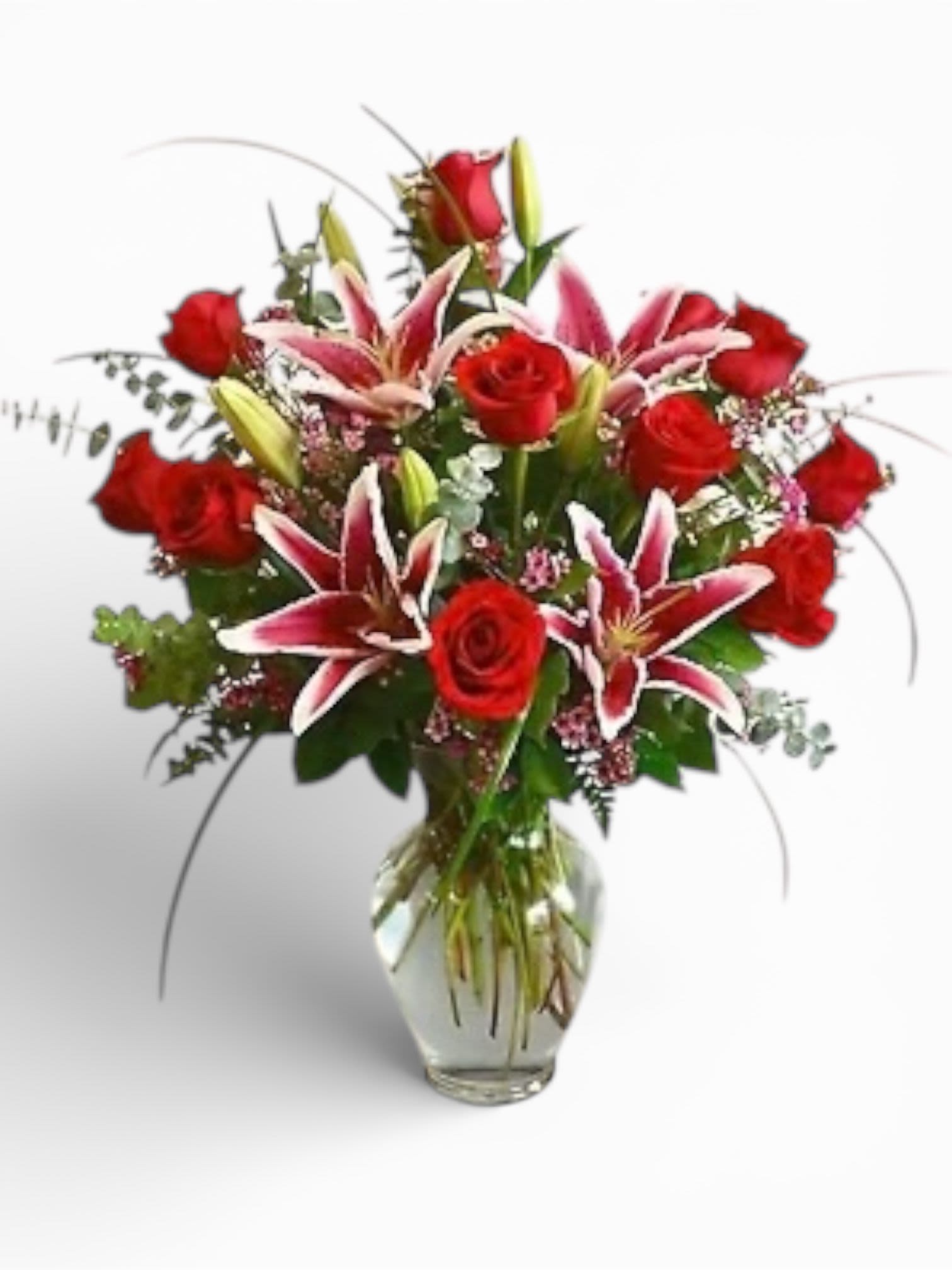 Red roses and pink lilies arranged in a clear glass vase