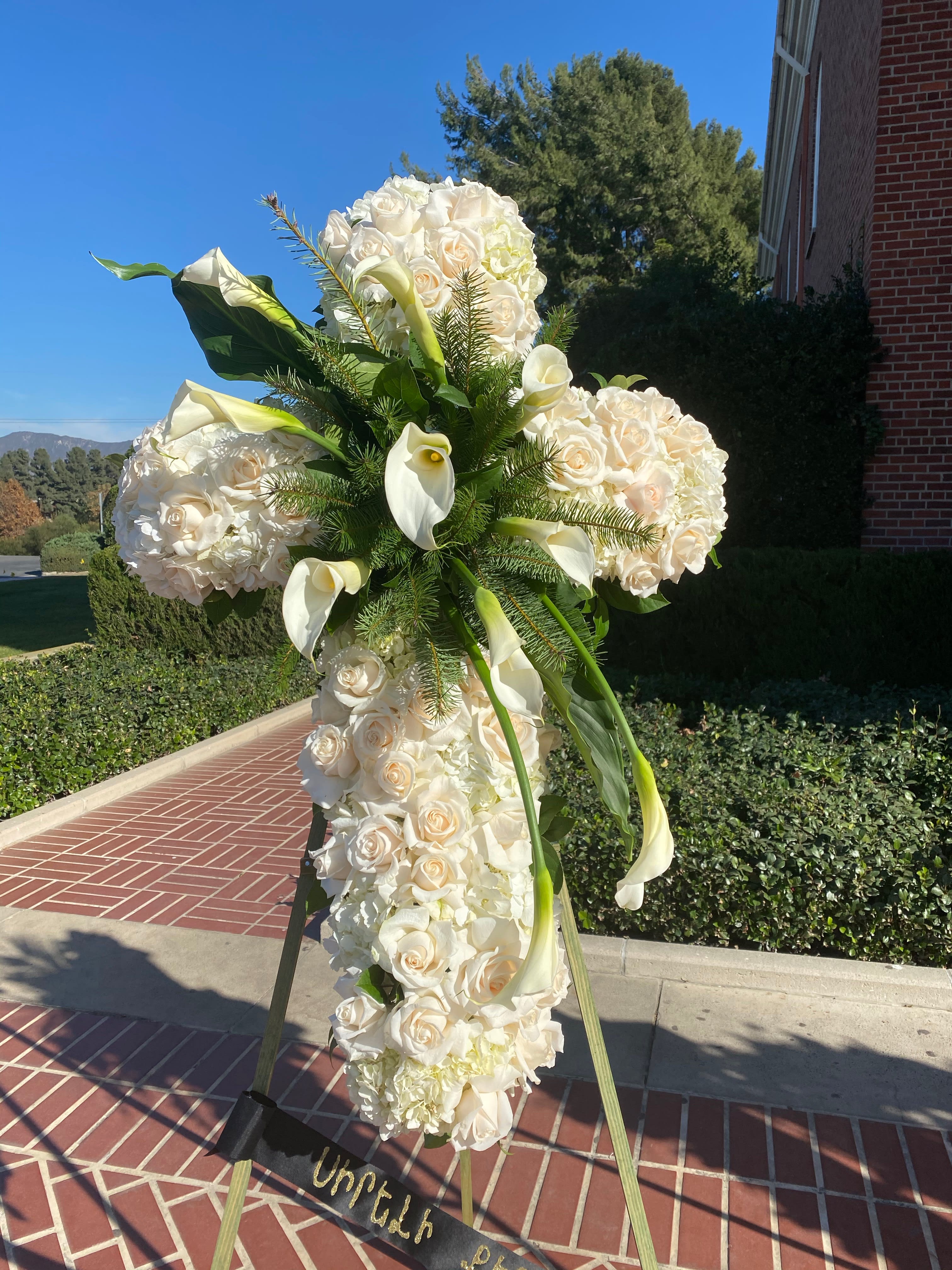 Tall white floral standing spray with roses and calla lilies