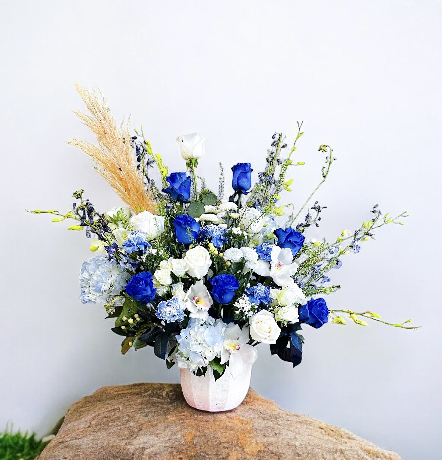 Blue and white floral arrangement in a white vase