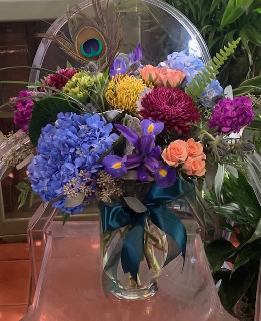 Colorful mixed bouquet in a clear glass vase with a teal ribbon
