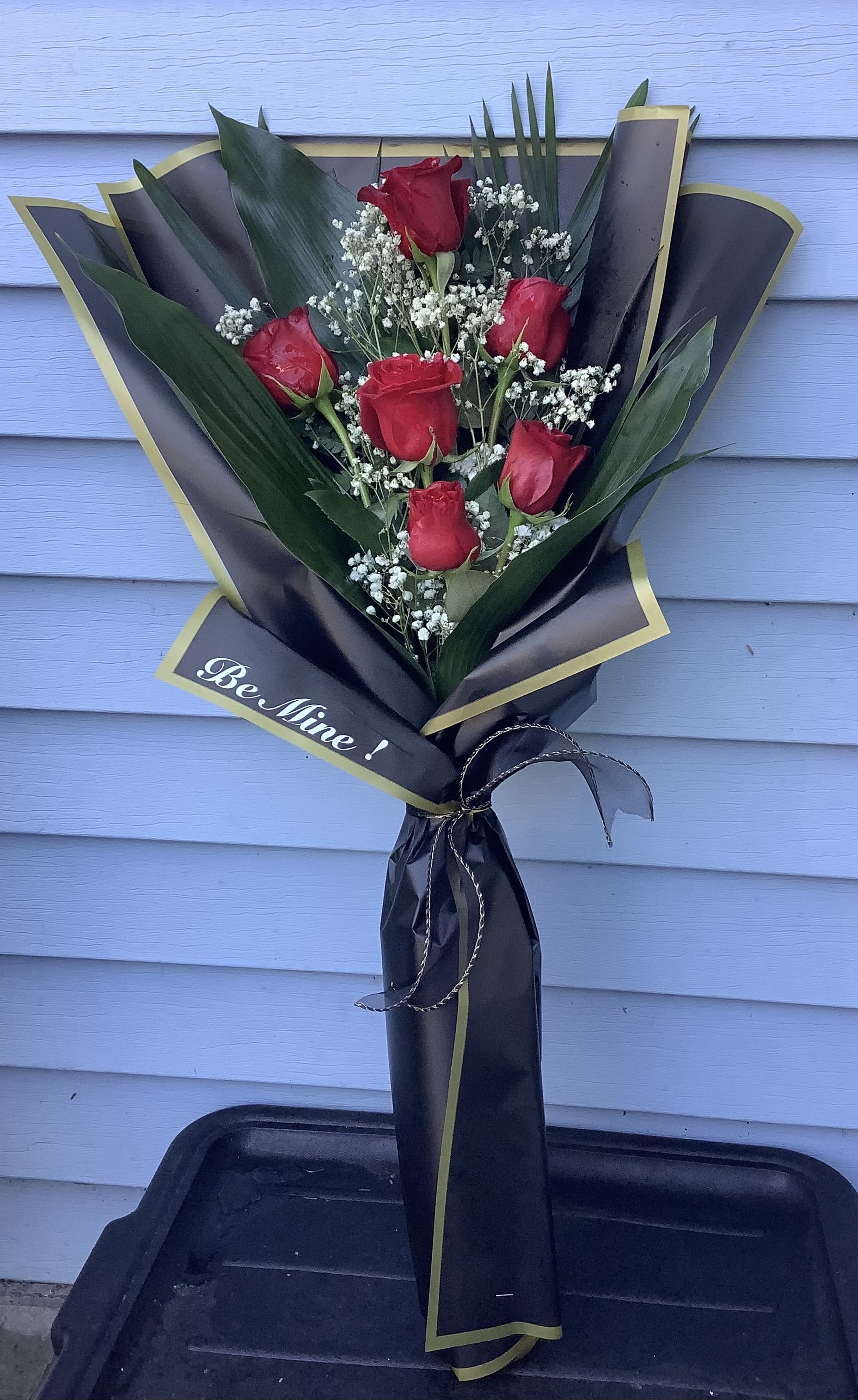 Bouquet of red roses with baby's breath in black and gold wrap