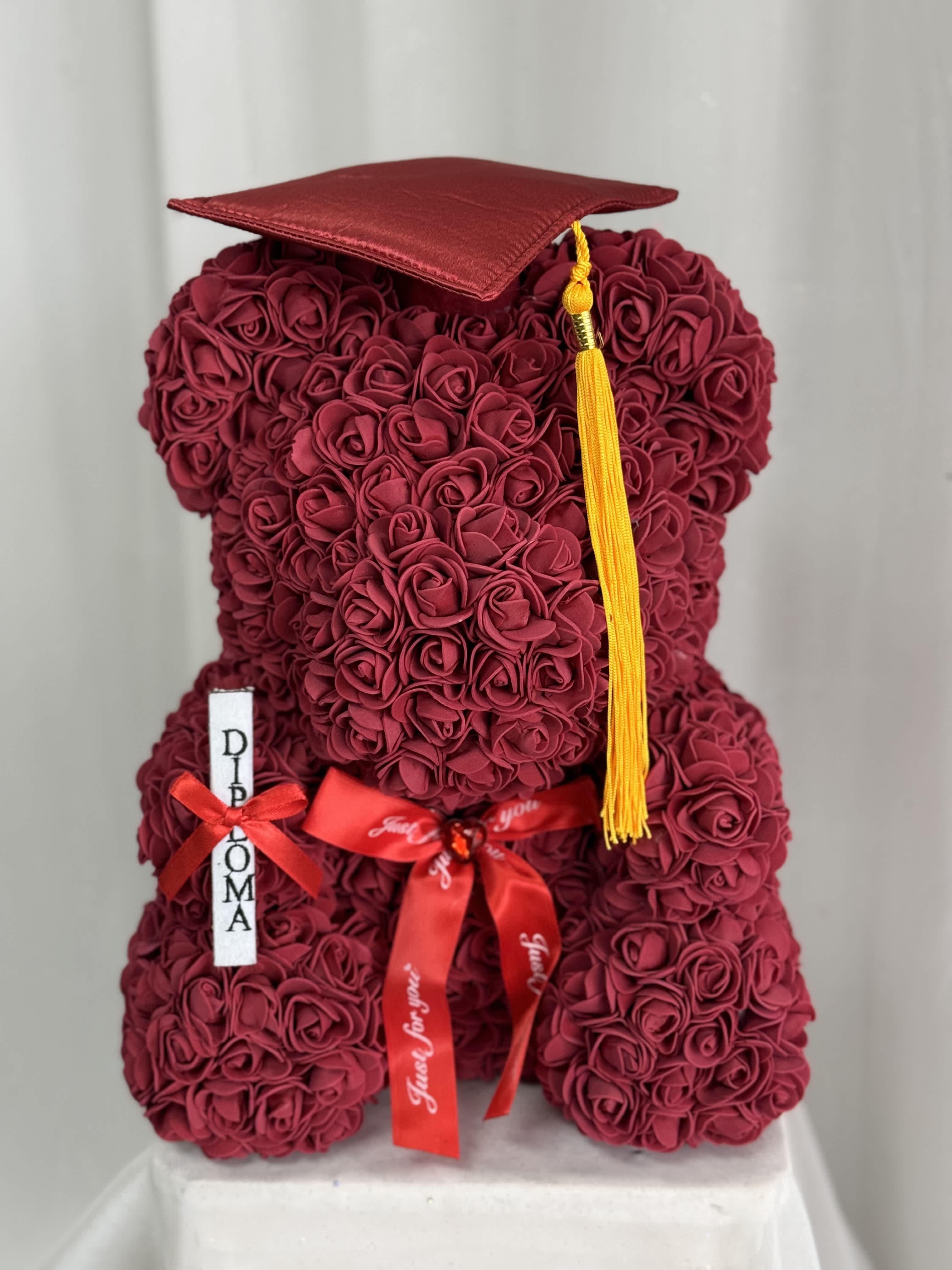  Faux Burgundy Rose Graduation Teddy Bear - Each lovely, Styrofoam, Rose Teddy Bear is 100% handmade and covered with soft, faux, rose petals that are individually added. Each bear arrives in a window display box that is 15 in height and 11 in width, perfect for sitting on a shelf or table. They're designed to be durable and will last a lifetime if handled with care. They make a beautiful and eye-catching decoration in any room or even at the office. Every time she looks at it, she'll remember that special day. What a sweet memento!  Bear Dimension: 13" H x 10"W 