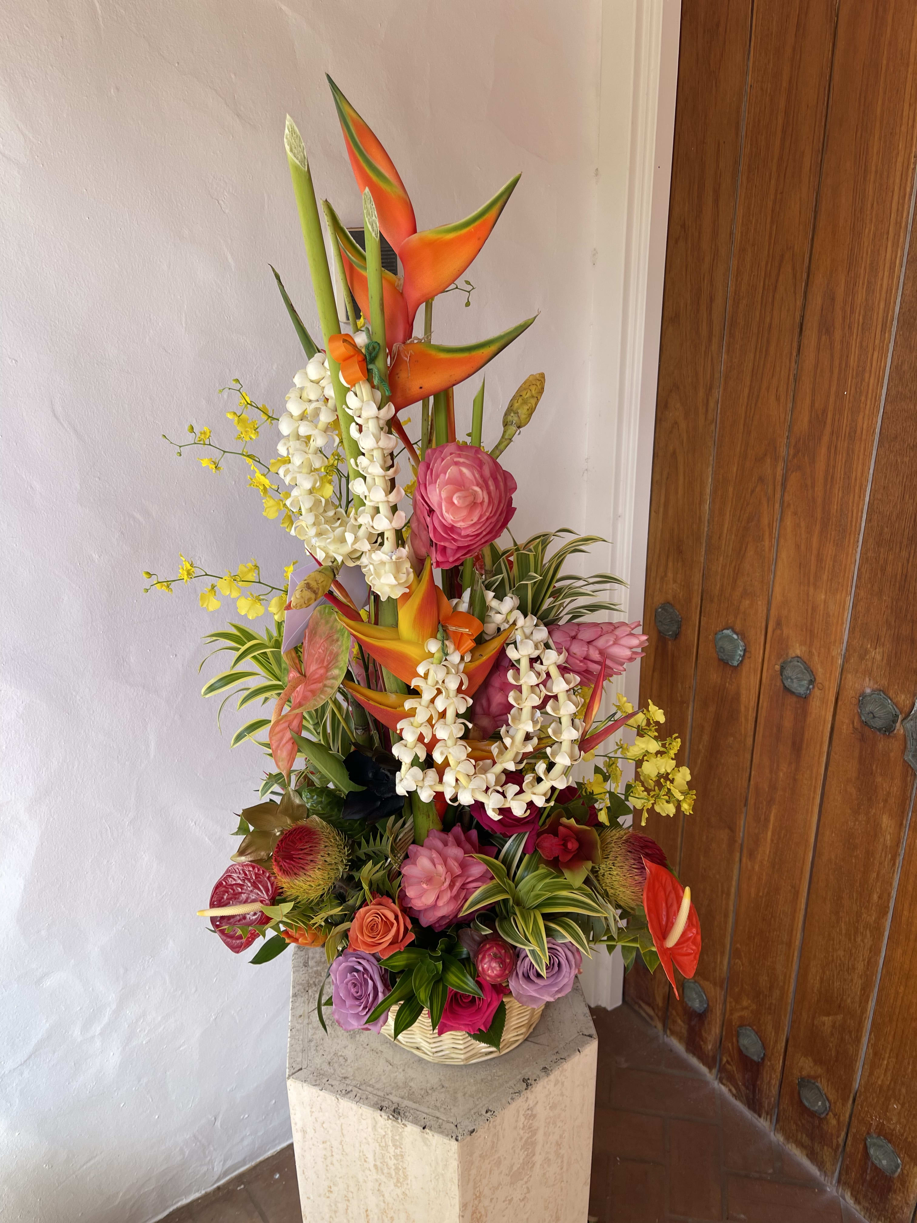 Incredible Tropical Floral tower Display  designers choice - A plethora of fresh tropical blooms locally grown in the islands of Hawaii  topped with florist choice two  Floral leis 