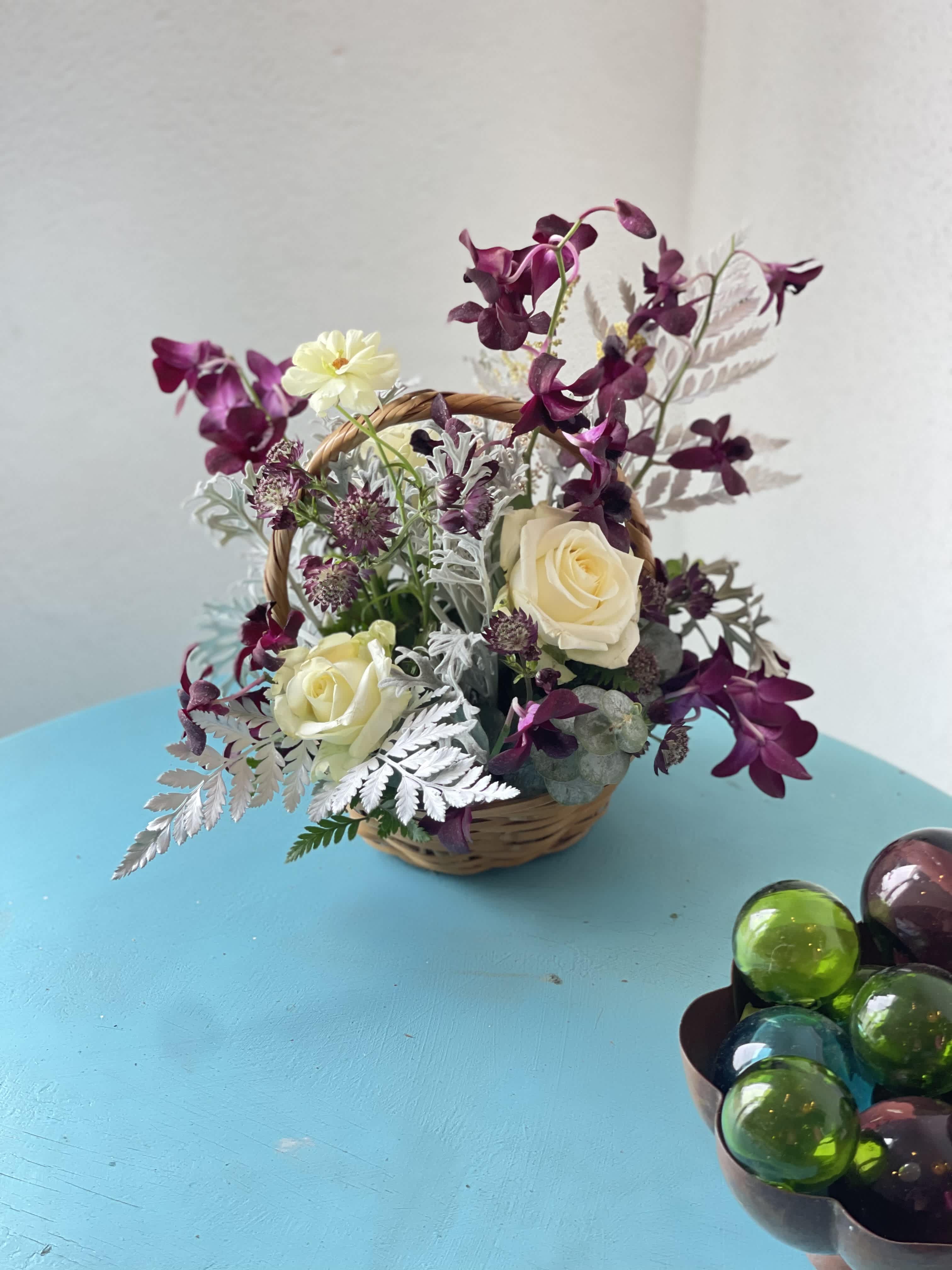 Nighttime whispers &amp; morning laughter - Dark purples, partnered with cream and white blooms. This exotic twist play with color will invite you to a world of slumber. A starry night sky inspired arrangement is perfect for the nighttime lover, the sweet whispers of Gothic kisses in the moonlight  this arrangement is not only stunning but perfect for the inner rockstar 