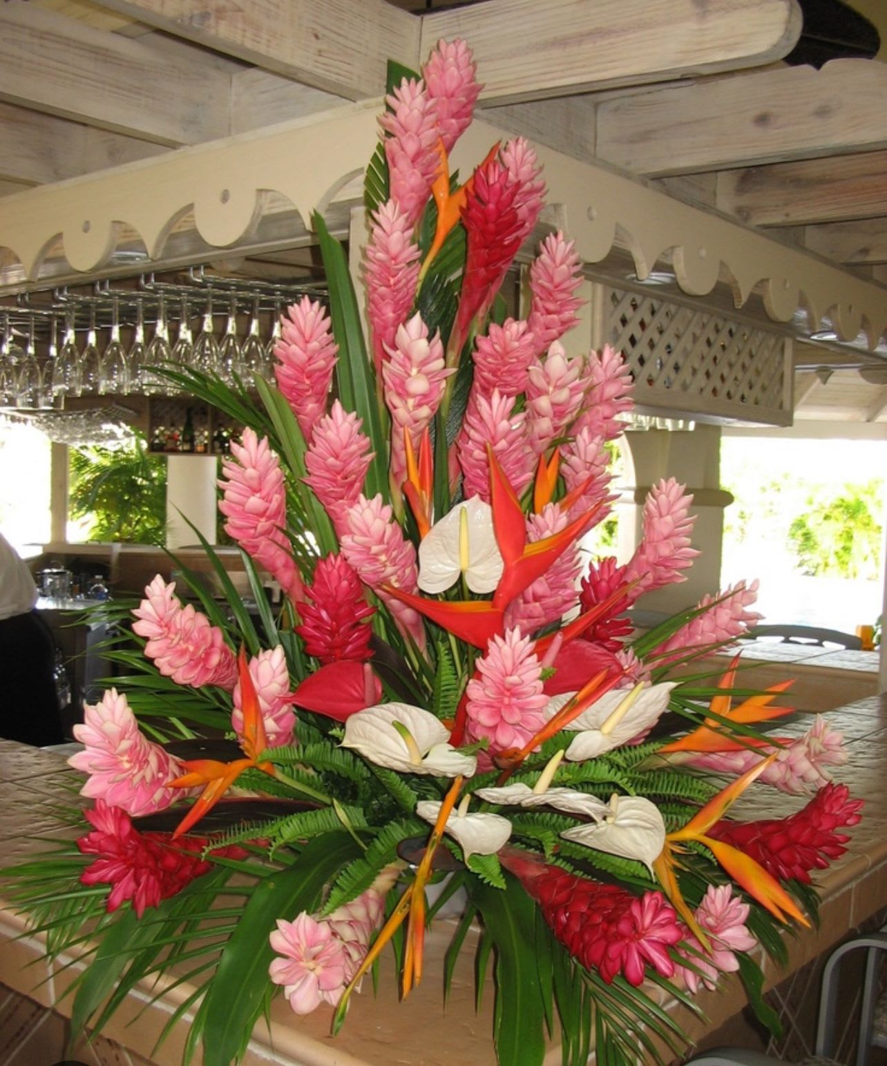 Mother’s Day, tropical special - This exotic tropical tower displays a mixture of this seasons, designer choice, tropical flowers filled with exotic greens with a wonderful display of Hawaiian florals. Please let us know your color palette, and we will try our very best to accommodate you  And include your favorite colors our flower towers are approximately 3 1/2  4 feet tall, depending on the container and the length of the tropical blooms and making sure that the flowers are not too long. We don’t want the arrangement to fall over graceful balancing with these taller arrangements displayed in a sturdy ceramic or plastic Decorative  container.   