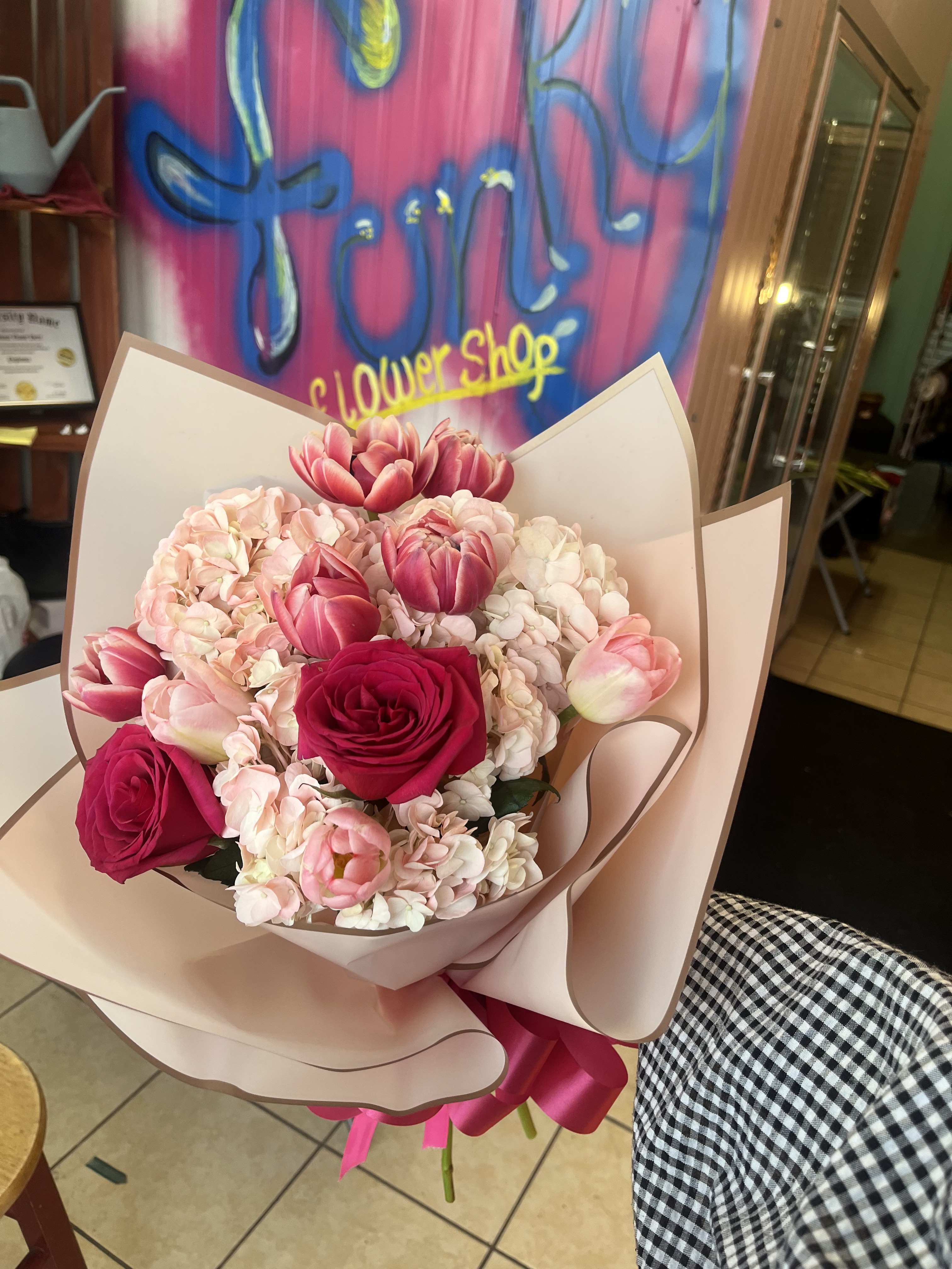 Pink and white bouquet with roses and tulips wrapped in blush paper