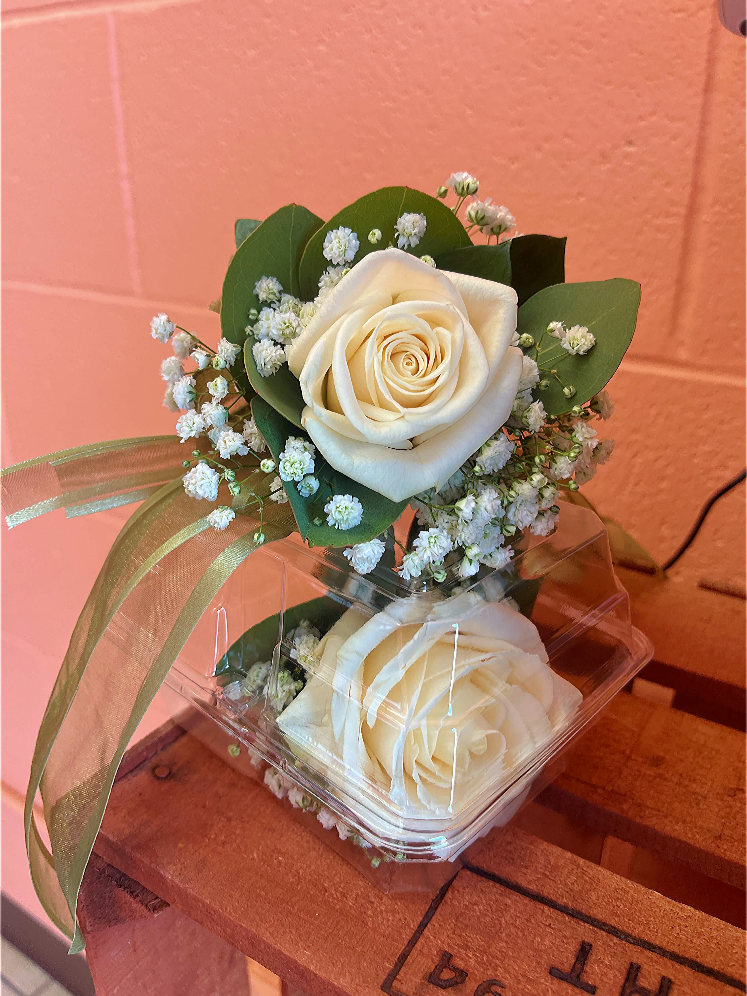 Two white roses with baby's breath in a clear box