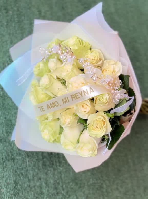 Bouquet of pale yellow roses wrapped in pastel paper with a decorative ribbon