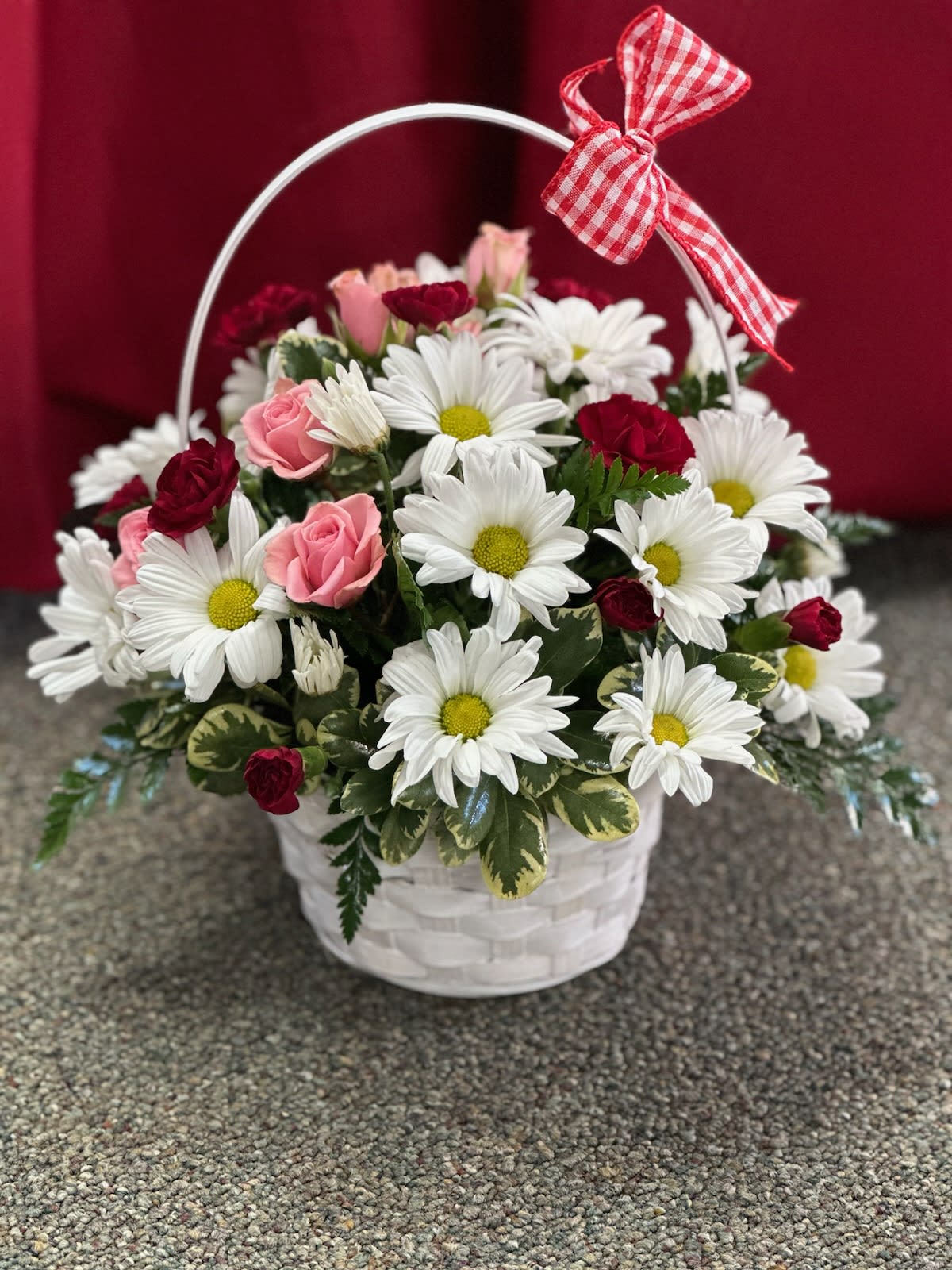 Basket of white daisies and pink roses with a red gingham bow