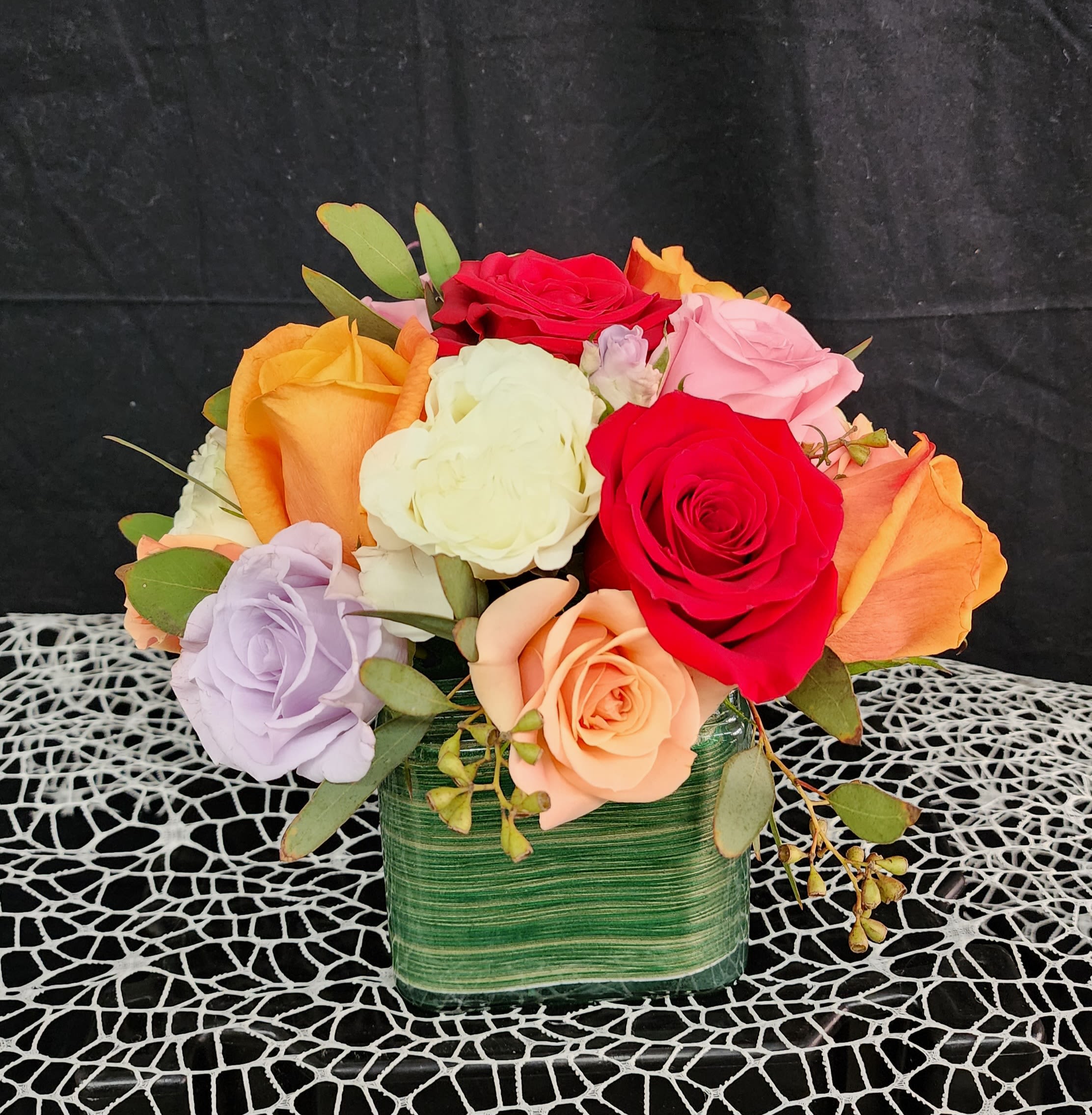 Colorful rose bouquet in a green square vase