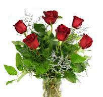 Bouquet of red roses with greenery in a clear vase