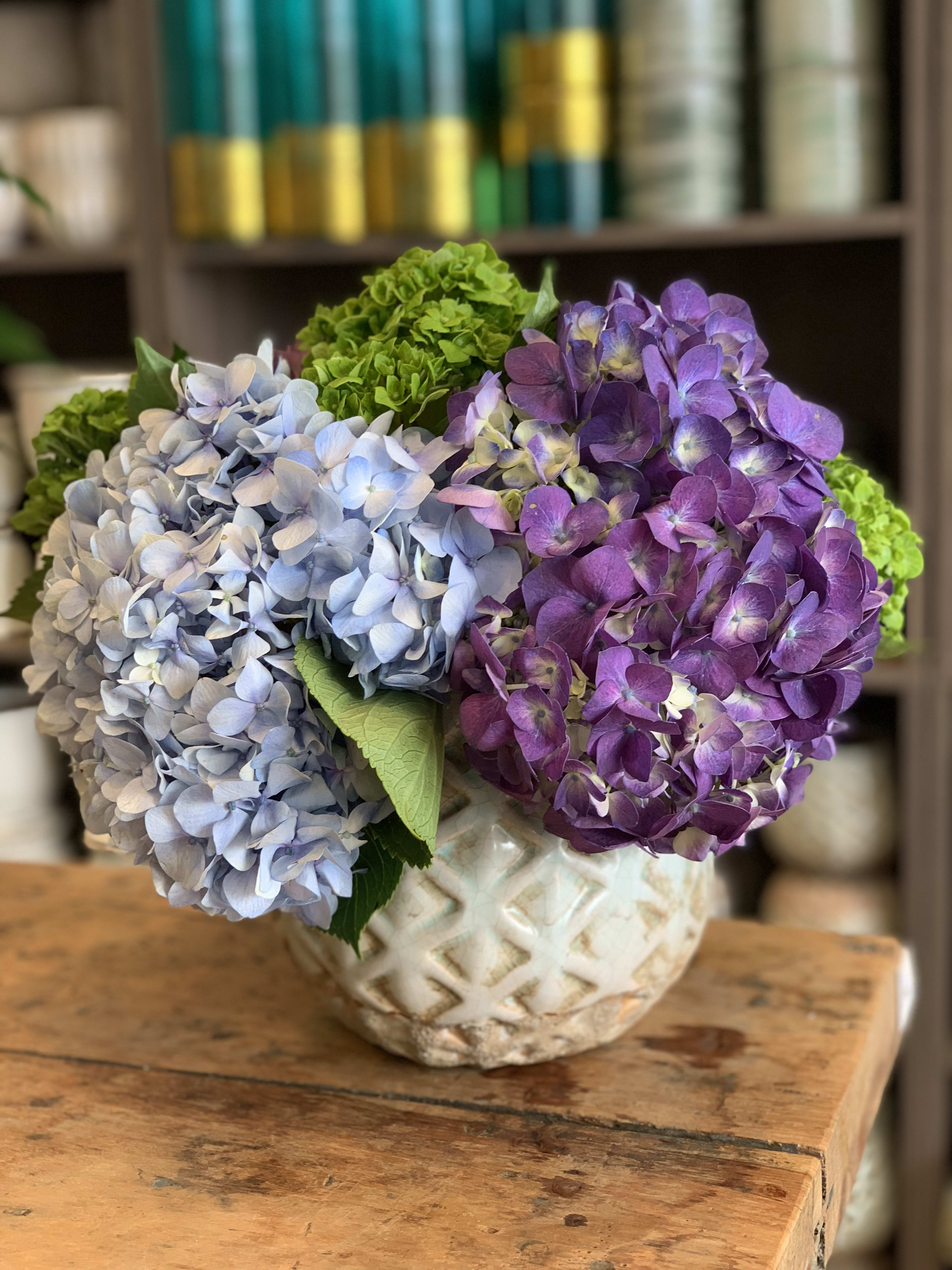 Blue and purple hydrangeas in a patterned ceramic vase
