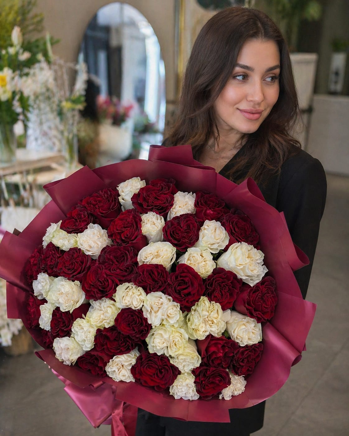 Roses Burgundy &amp; White Luxury Bouquet - A luxurious hand-tied bouquet featuring 50 premium roses in an elegant burgundy and ivory white color palette. Designed with rich contrast and modern luxury wrapping, this arrangement creates a bold and sophisticated statement. The deep wine-red roses symbolize passion and elegance, while soft ivory roses add balance and timeless beauty. Perfectly arranged in a full, rounded design for an upscale presentation. Ideal for Anniversaries, Romantic Gifts, Birthdays, Luxury Celebrations, Valentine’s Day, and Special Occasions. Please note: rose shades may slightly vary depending on seasonal availability, while the overall look, color palette, and bouquet style will remain consistent with the photo. Handcrafted by Felice Flowers &amp; Design.