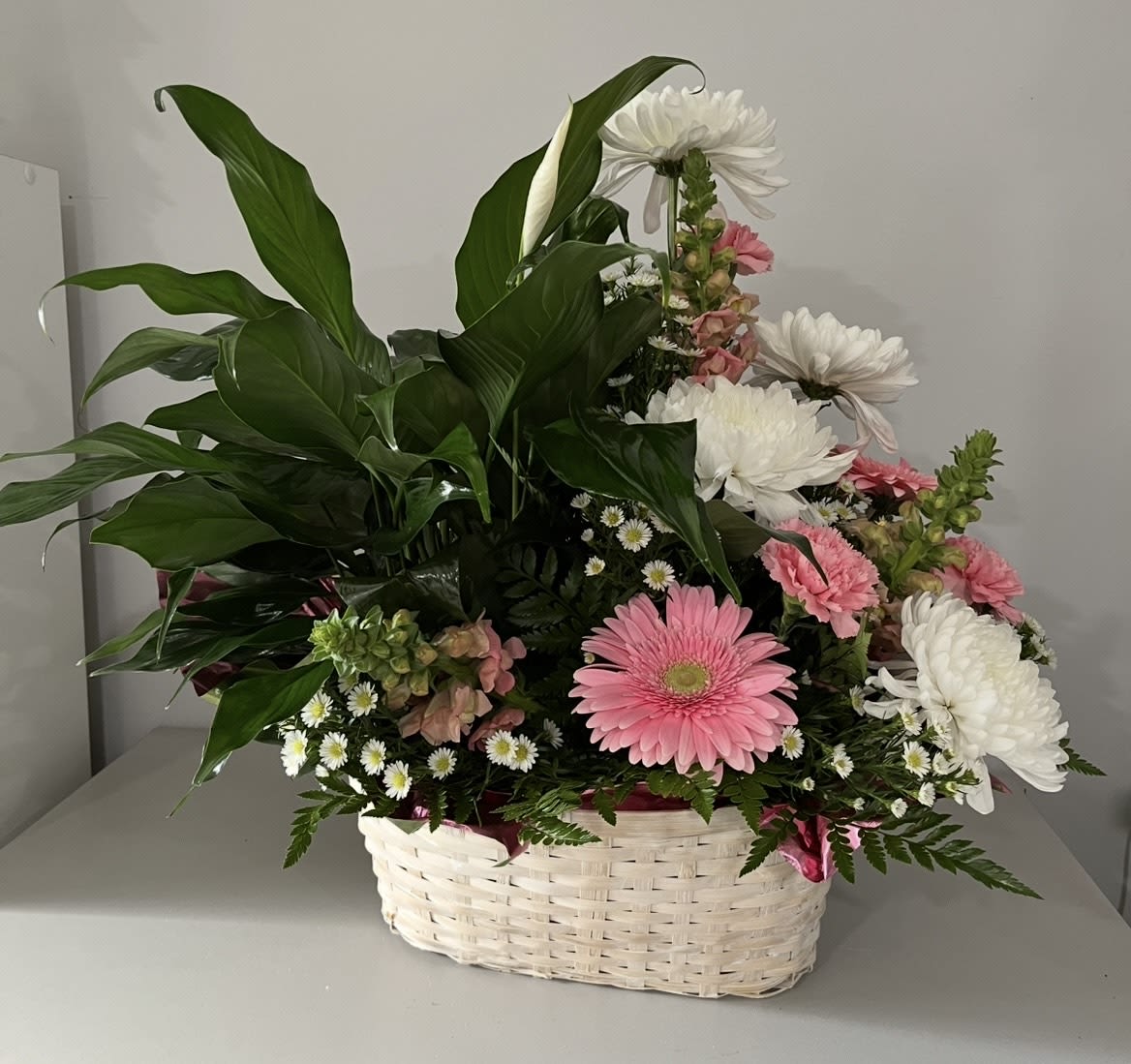 Basket arrangement with pink and white daisies and mixed blooms