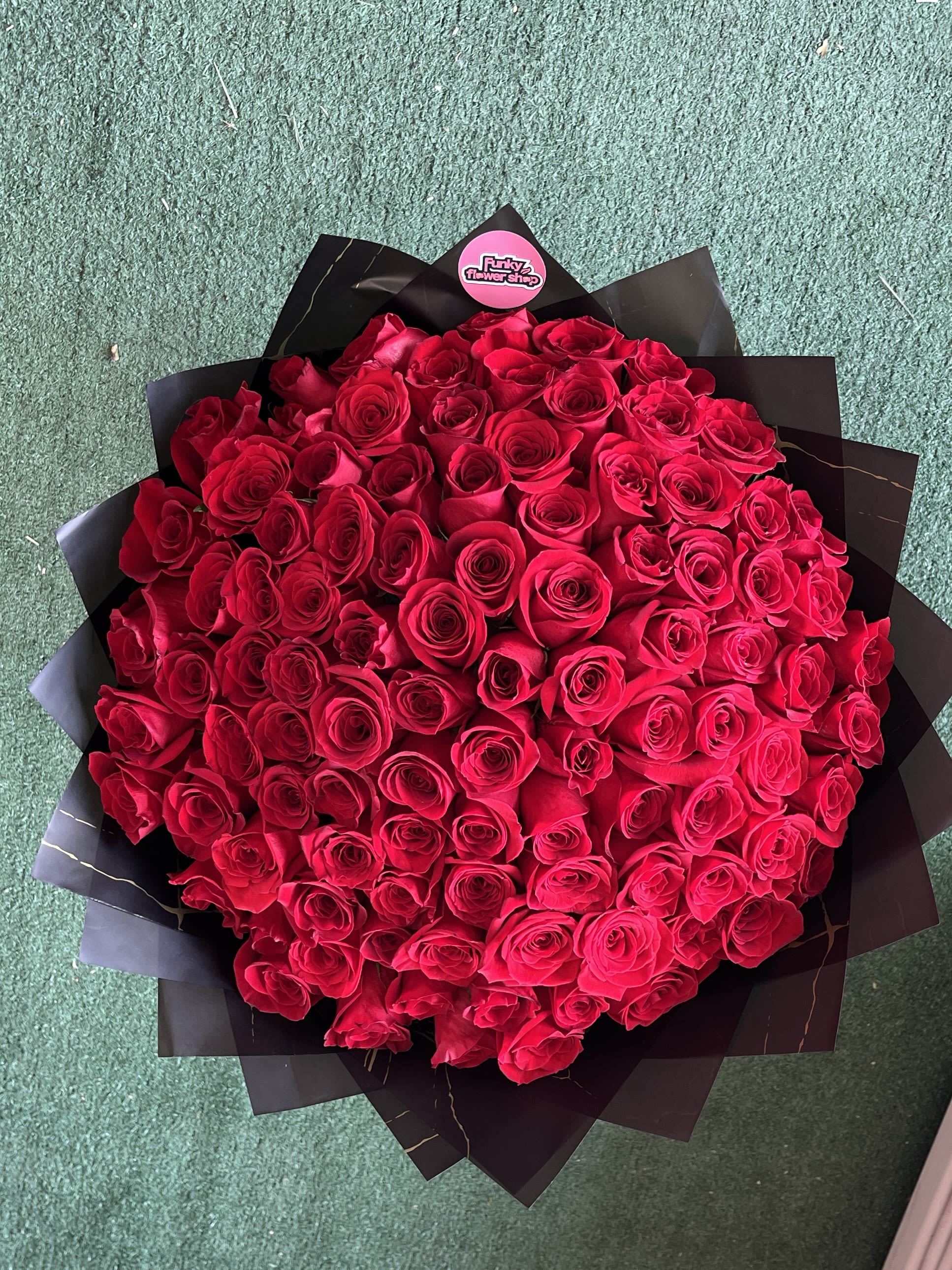 Large bouquet of red roses wrapped in black paper
