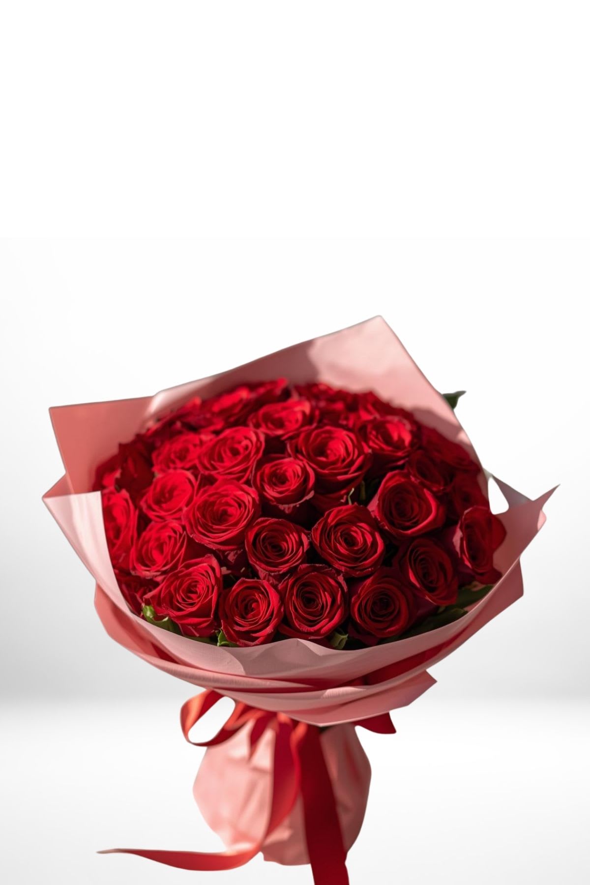 Bouquet of red roses wrapped in pink paper with a red ribbon