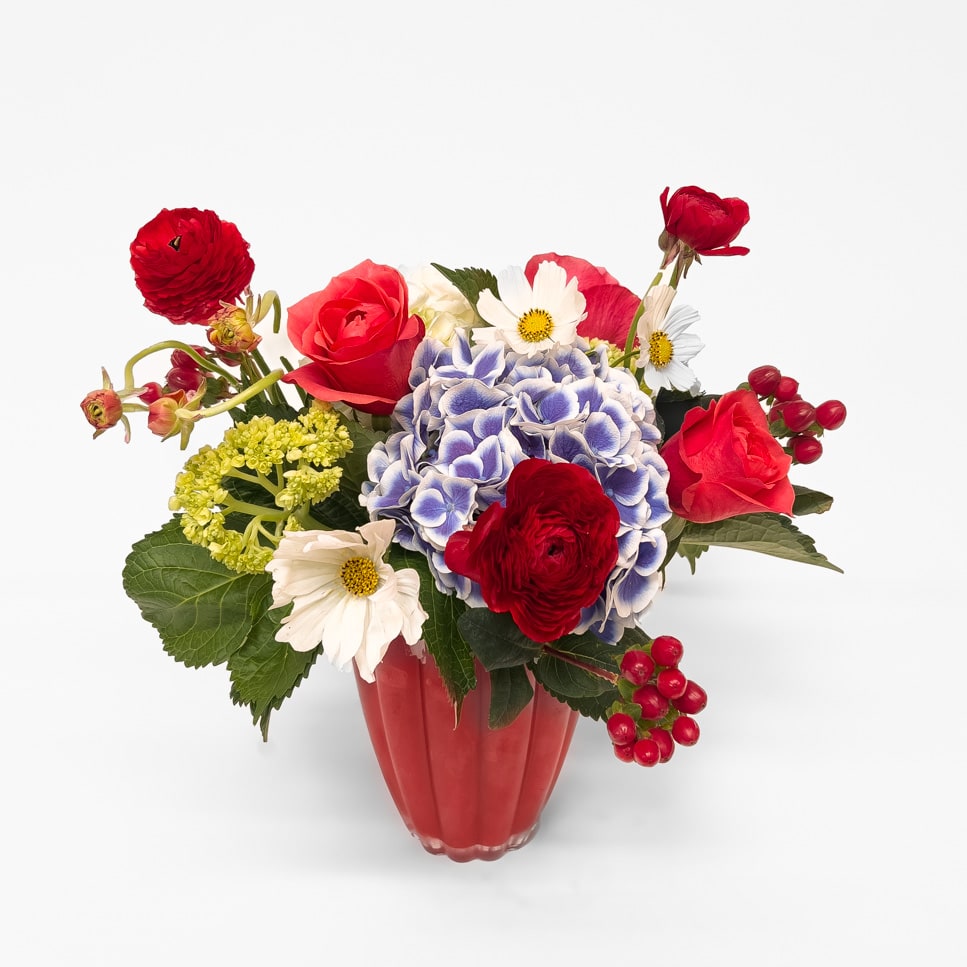 July - A festive mix of seasonal blooms in vibrant red, white, and blue tones inspired by summertime celebrations, backyard gatherings, and Fourth of July fireworks.