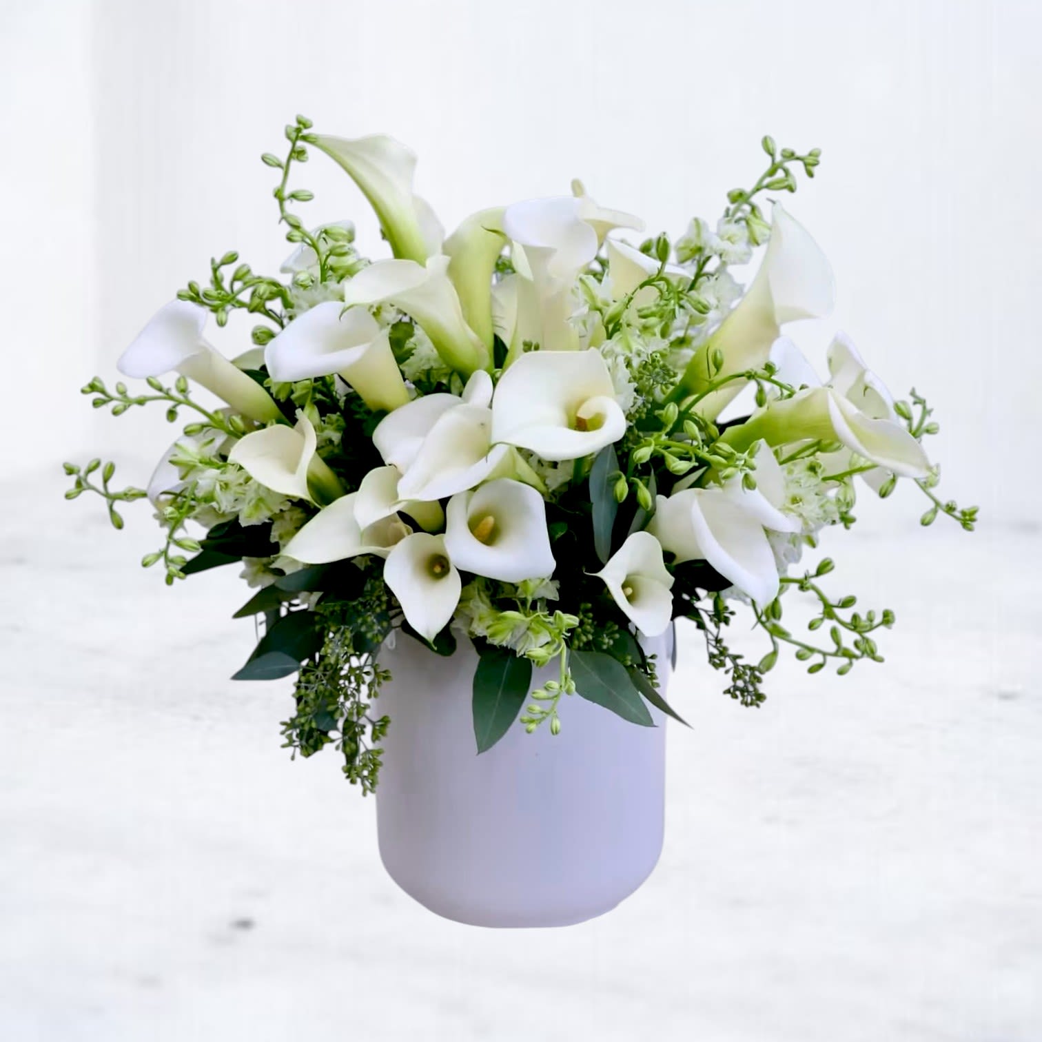 White calla lily bouquet in a pale vase