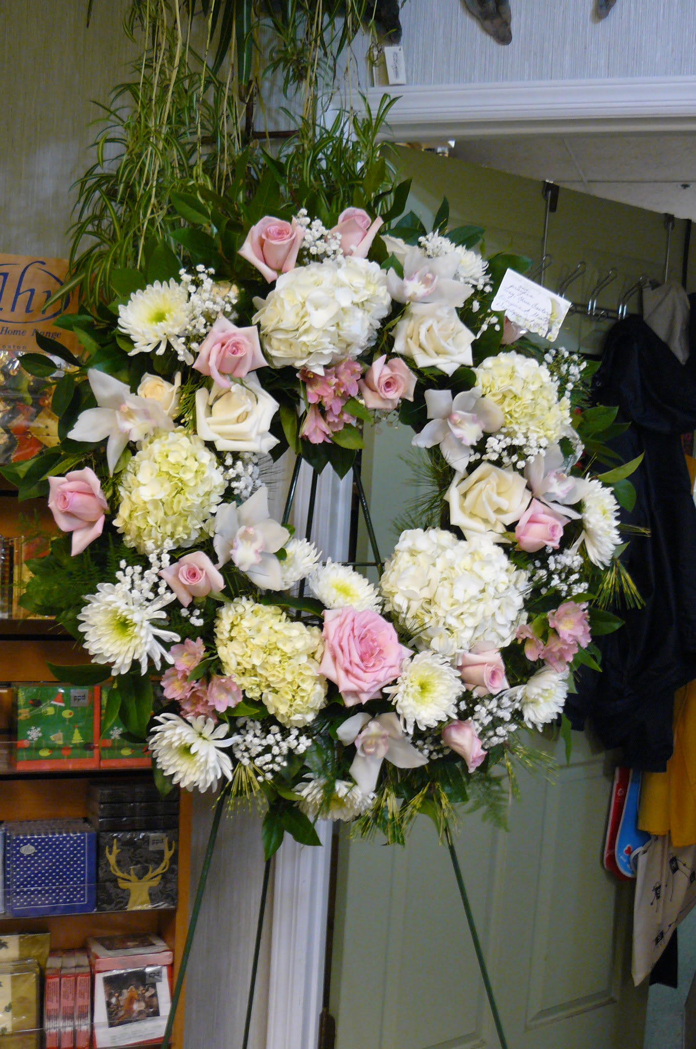 Large floral wreath on an easel with pink and white flowers