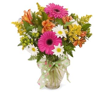 Mixed bouquet with pink gerberas, daisies, and orange alstroemeria in a glass vase