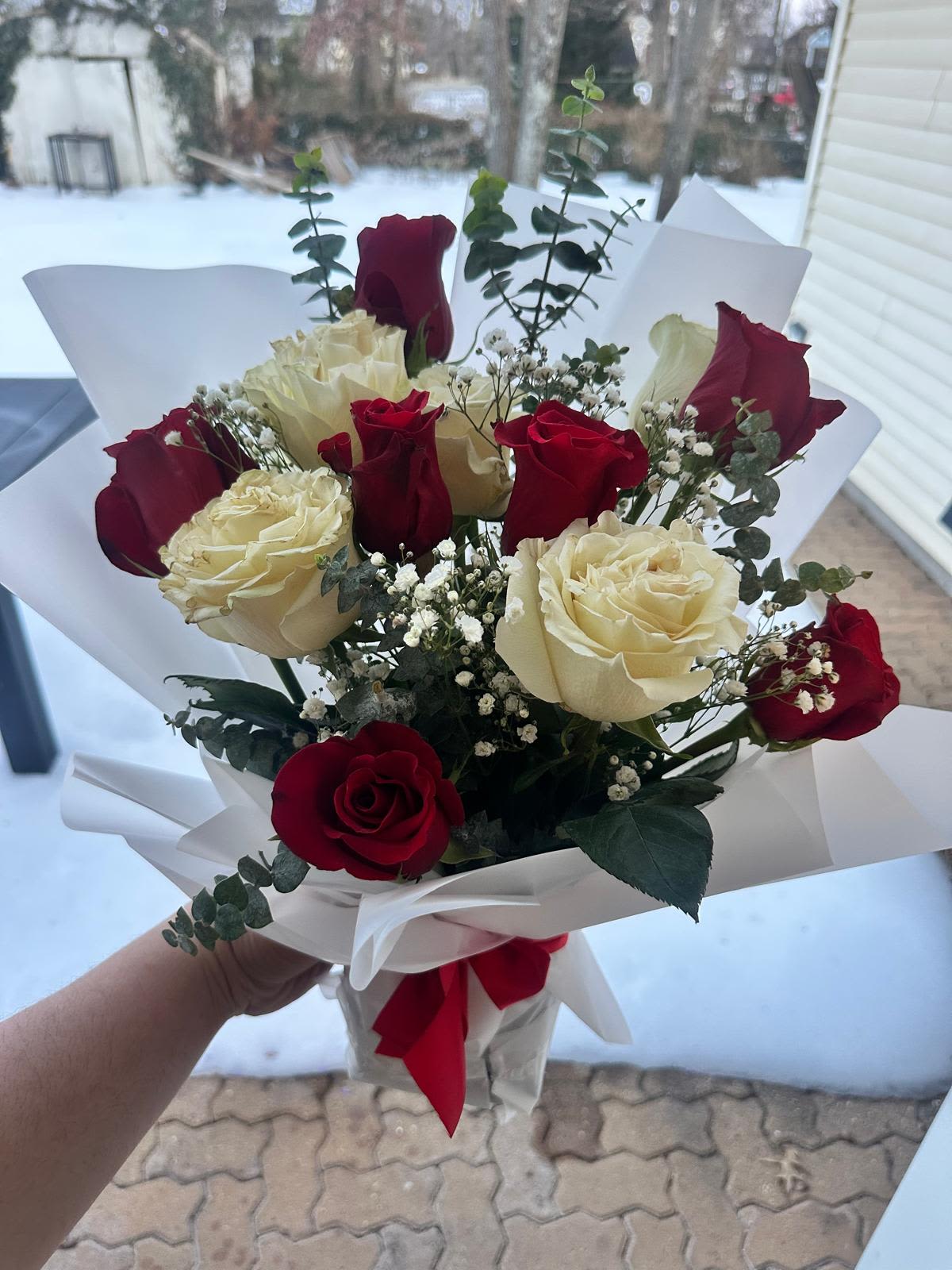 Passion Bouquet - This exquisite arrangement features premium, velvety red roses paired with delicate creamy white roses, beautifully accented with fresh eucalyptus leaves and whispers of baby's breath. Hand-wrapped in sleek white paper and finished with a vibrant red ribbon, the Passion Bouquet is the ultimate expression of love, romance, and sophisticated beauty. Perfect for anniversaries, birthdays, or simply saying "I love you."