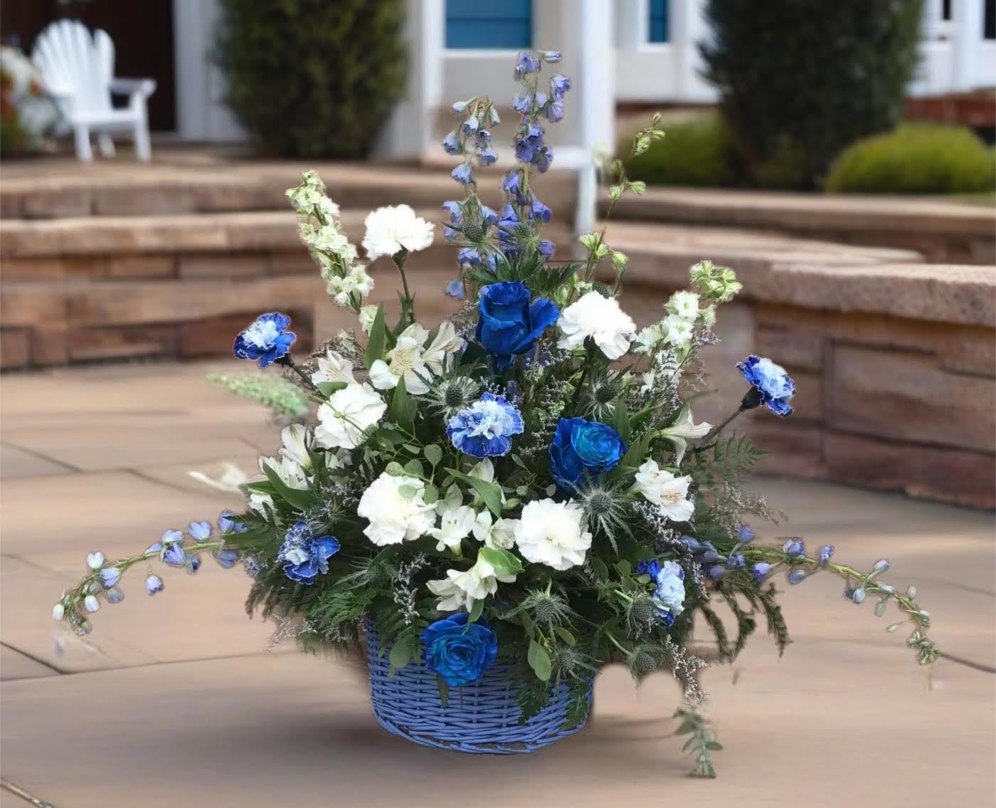 Blue and white floral arrangement in a blue basket